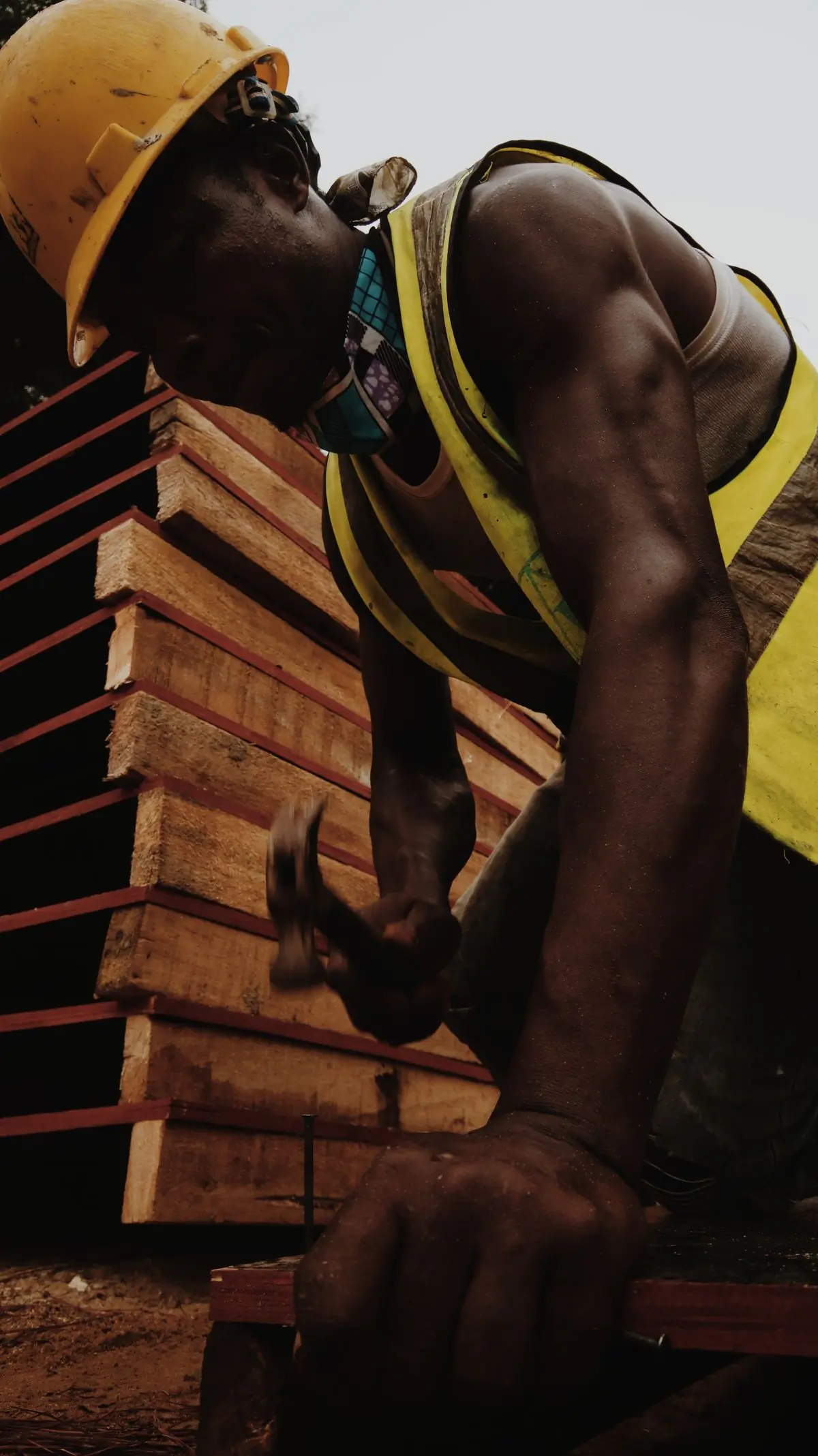 A carpenter driving a nail into a length of timber