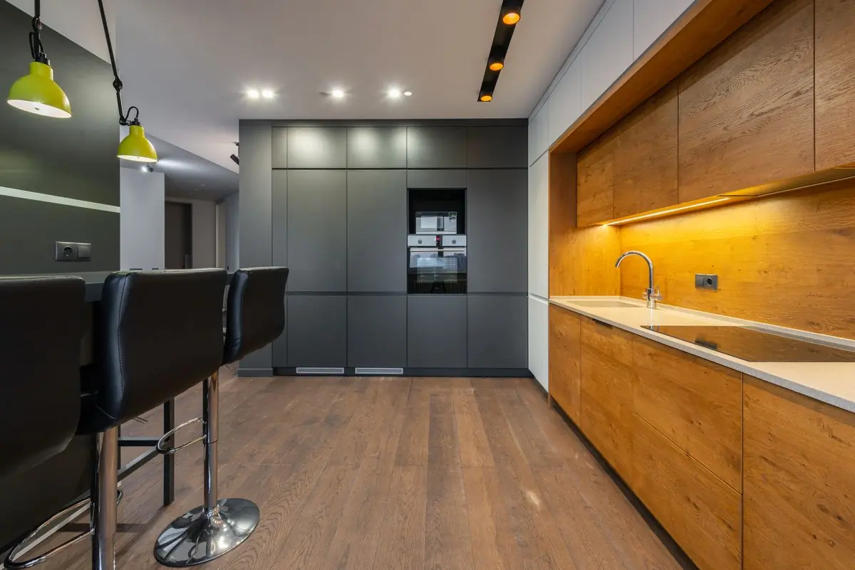 A finished kitchen with dark timber cabinets and stone counters