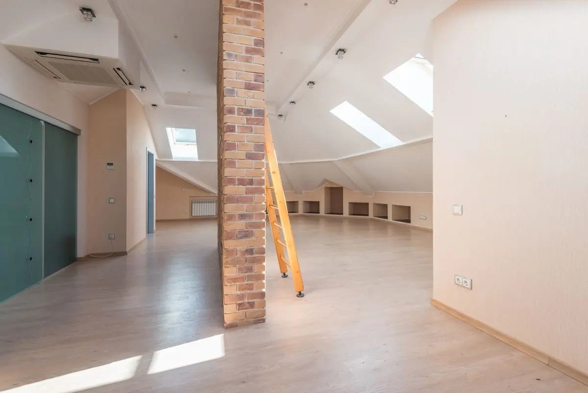 A converted roof space with exposed brick and skylights