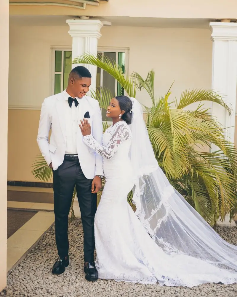 Efua and Selorm in wedding attire on a lawn