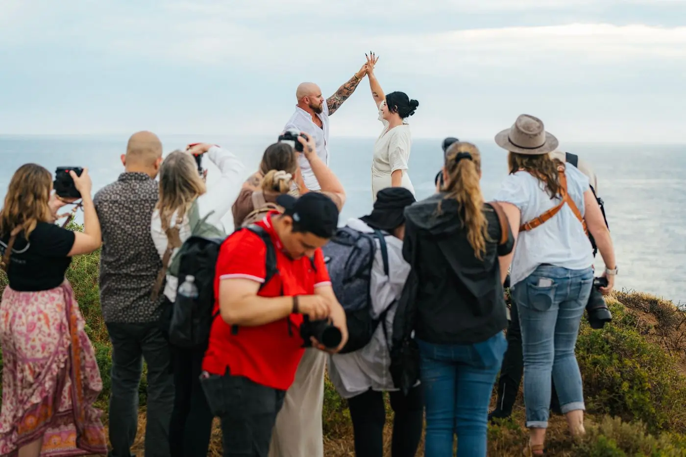 Two photographers working a couple's portraits on a clifftop