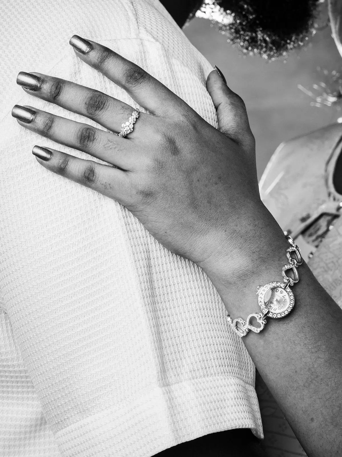 A close-up of an engagement ring on a hand, photographed in black and white in Accra