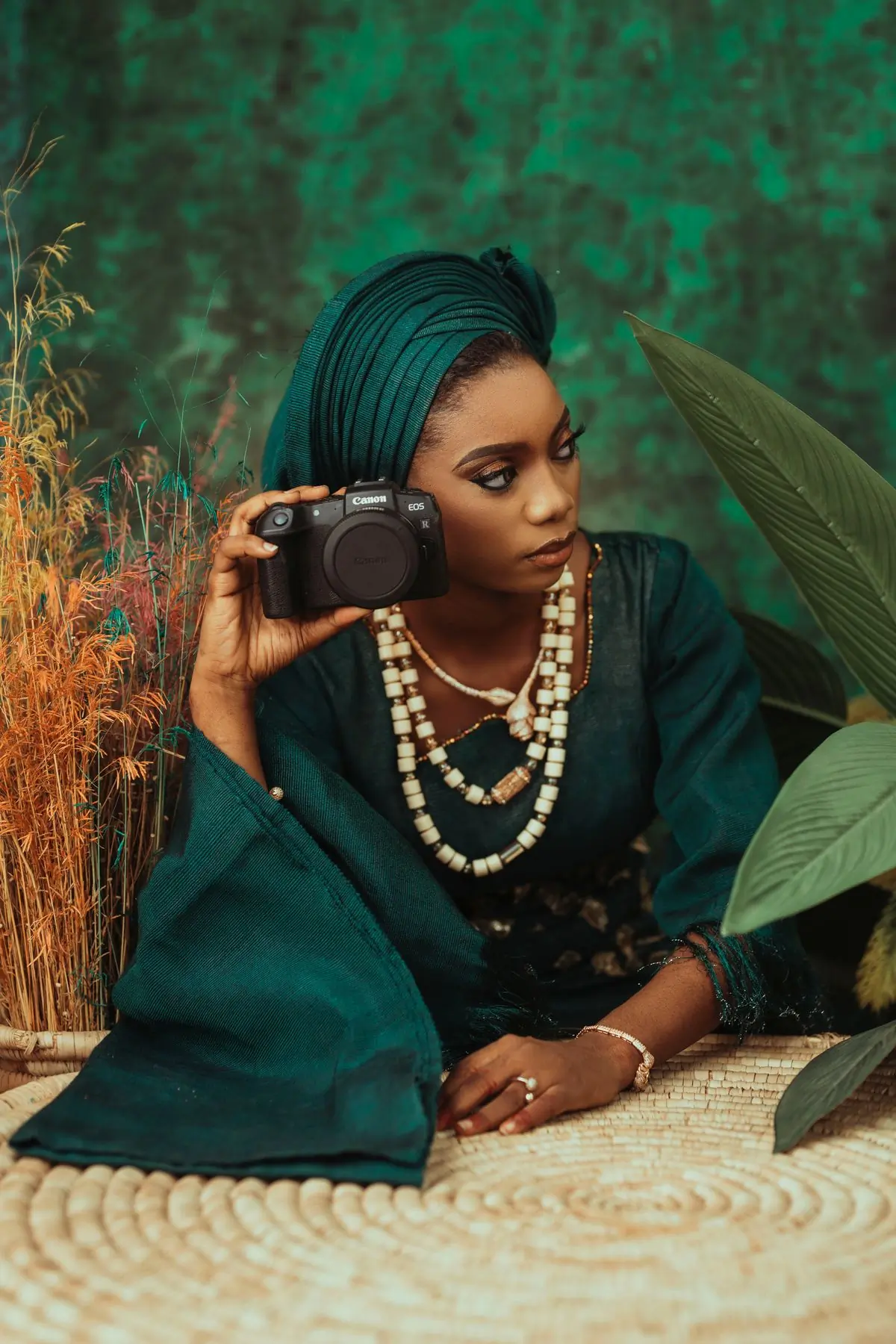A portrait of the photographer in green cloth, holding a camera
