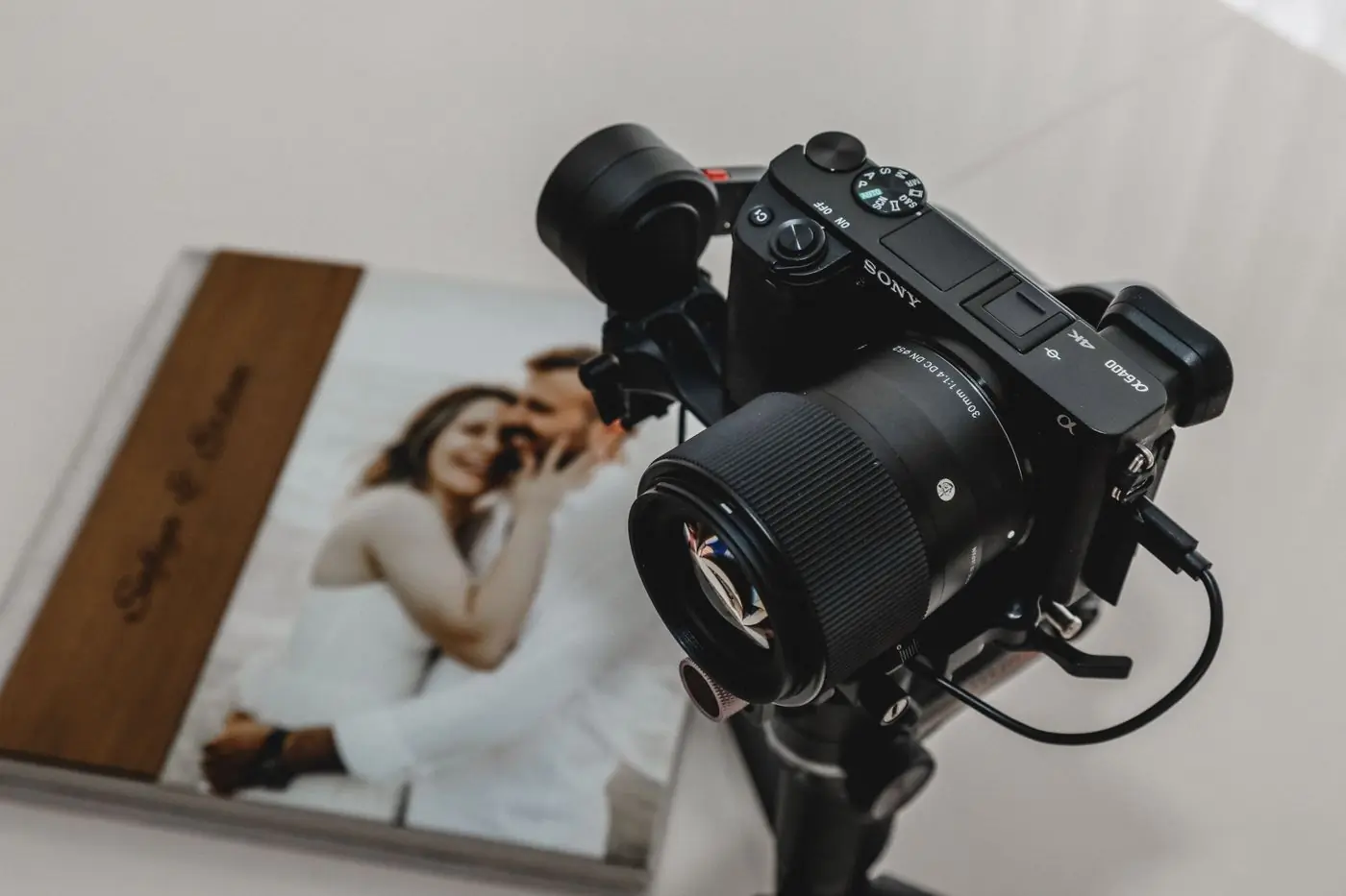 A lay-flat wedding album open beside a camera on a tripod
