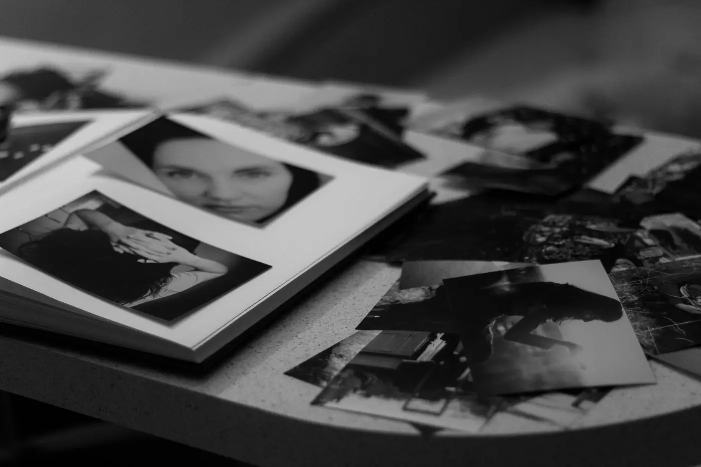 A pile of black-and-white prints spread across a table