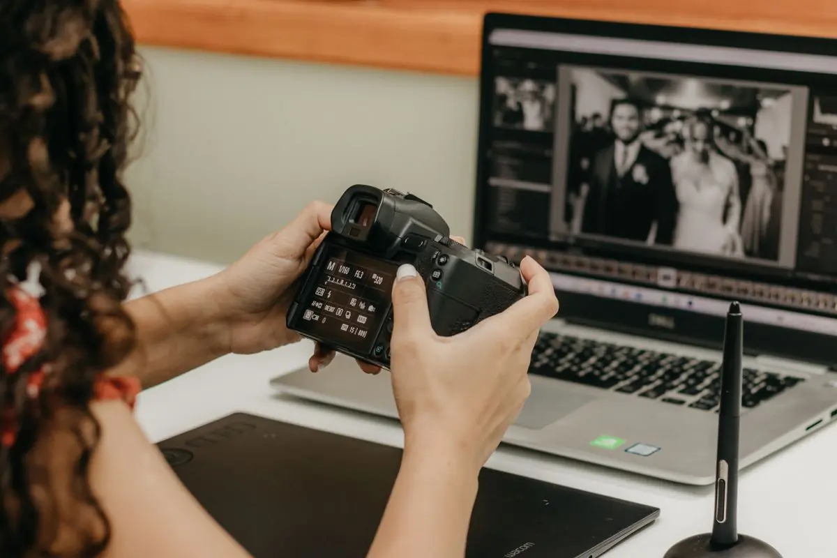 A photographer reviewing a black-and-white wedding frame at an editing desk
