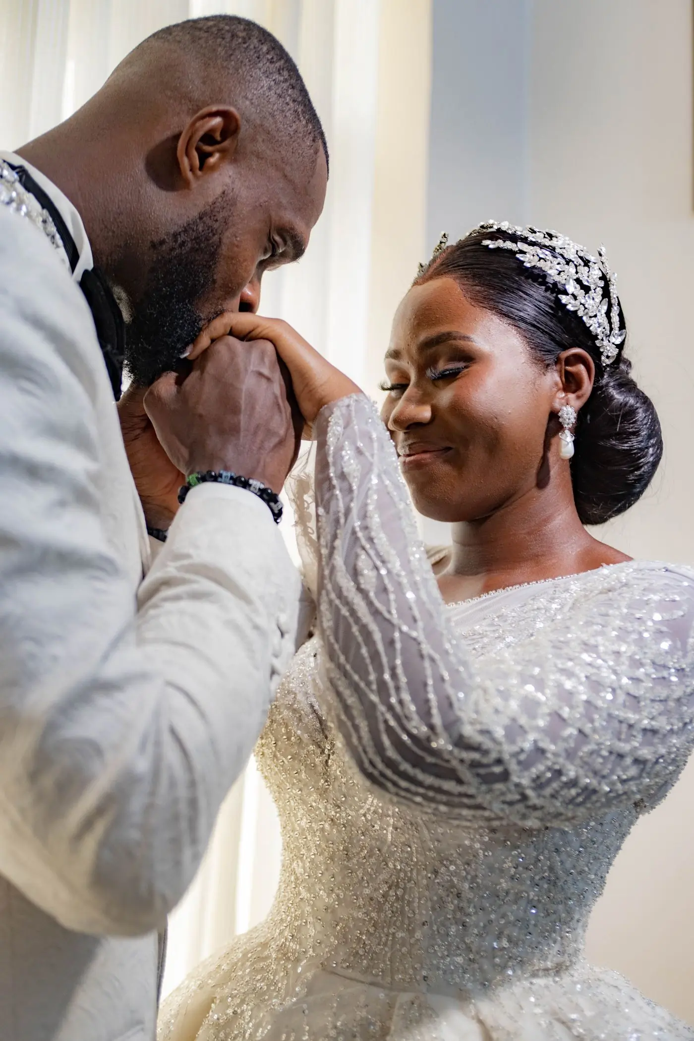 A groom cupping his bride's face during the blessing at an outdoor ceremony