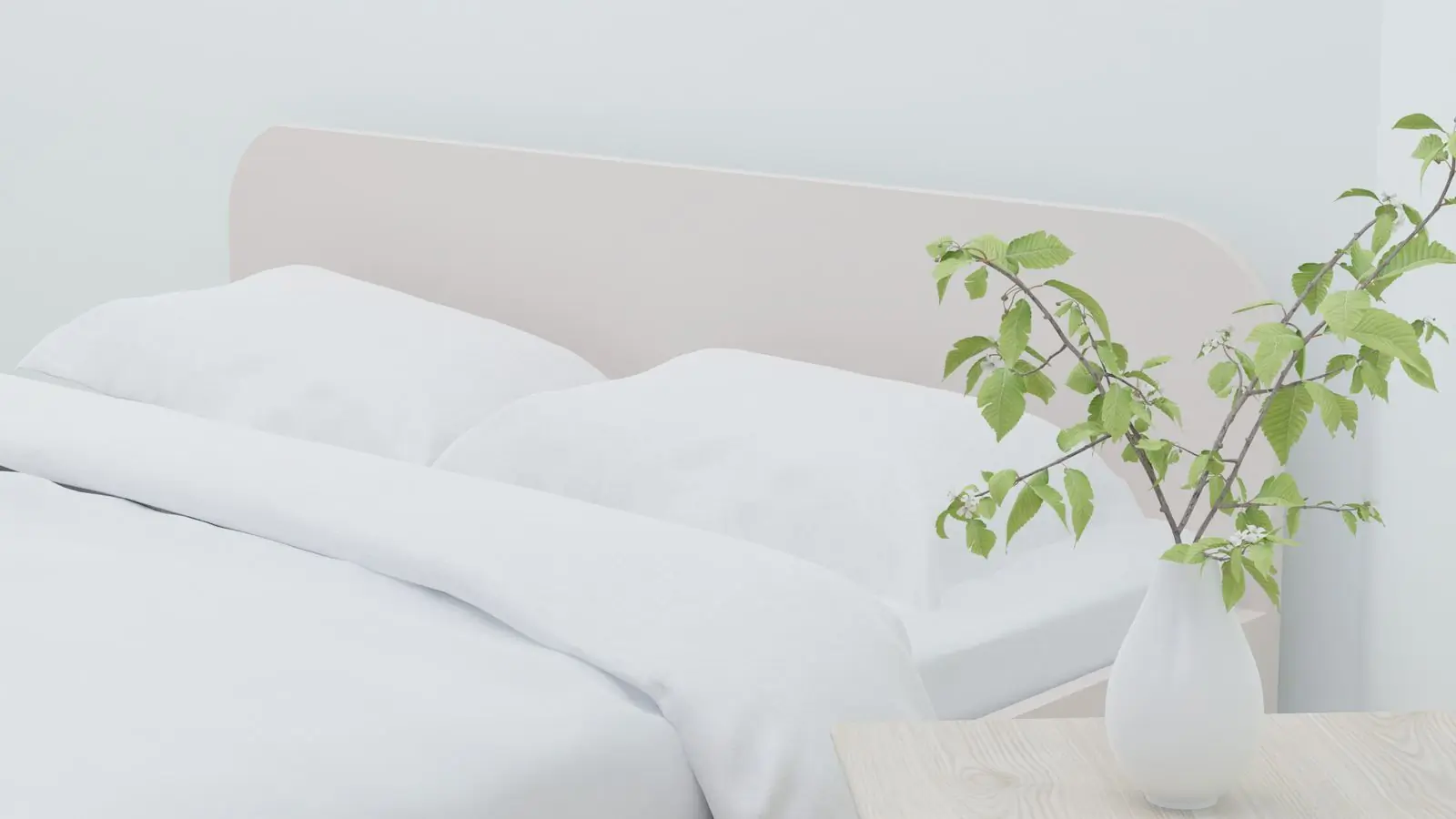 A minimal bed dressed in light linen