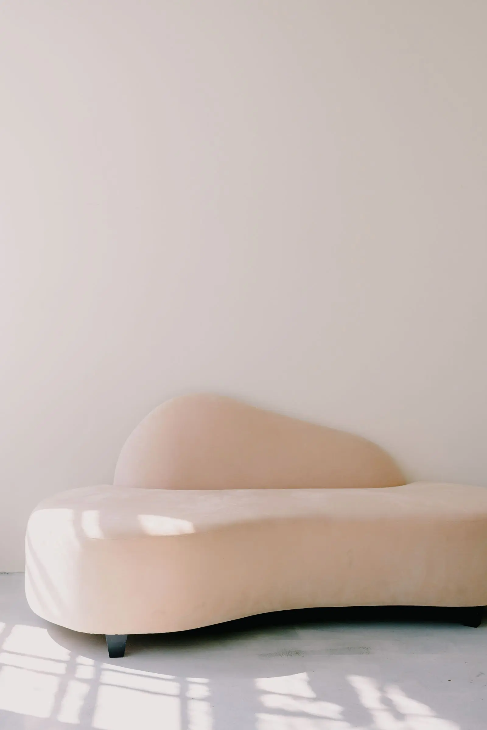 A neutral three seater sofa against a plain wall