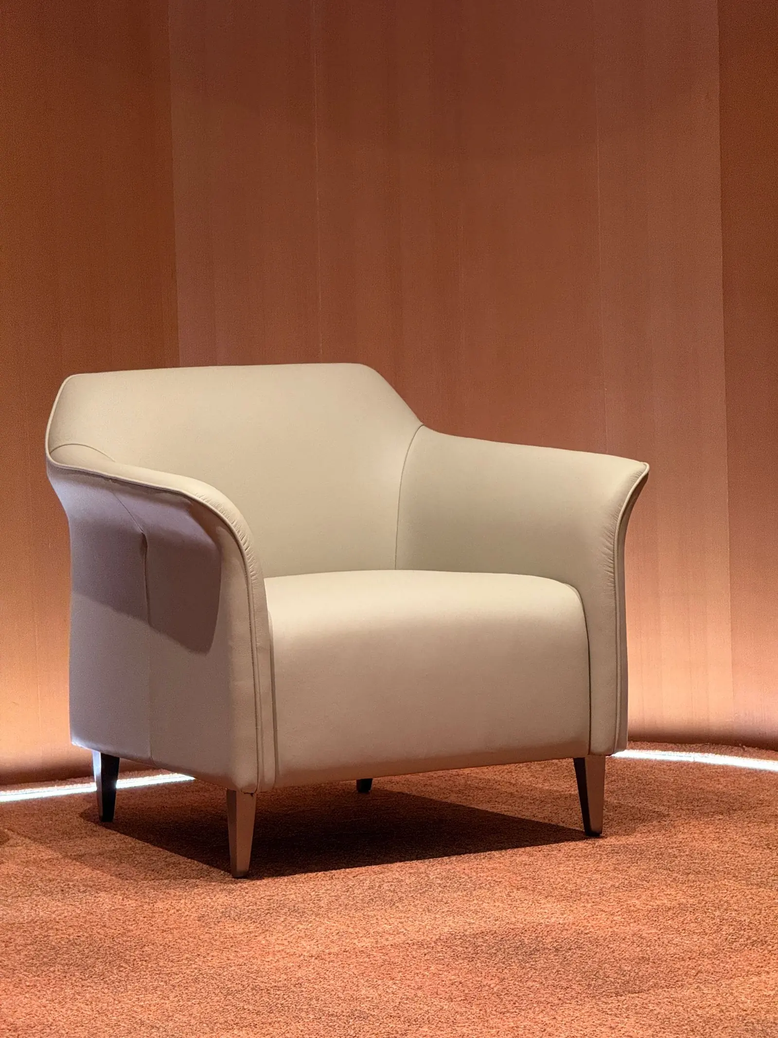 A curved lounge chair with cream boucle upholstery
