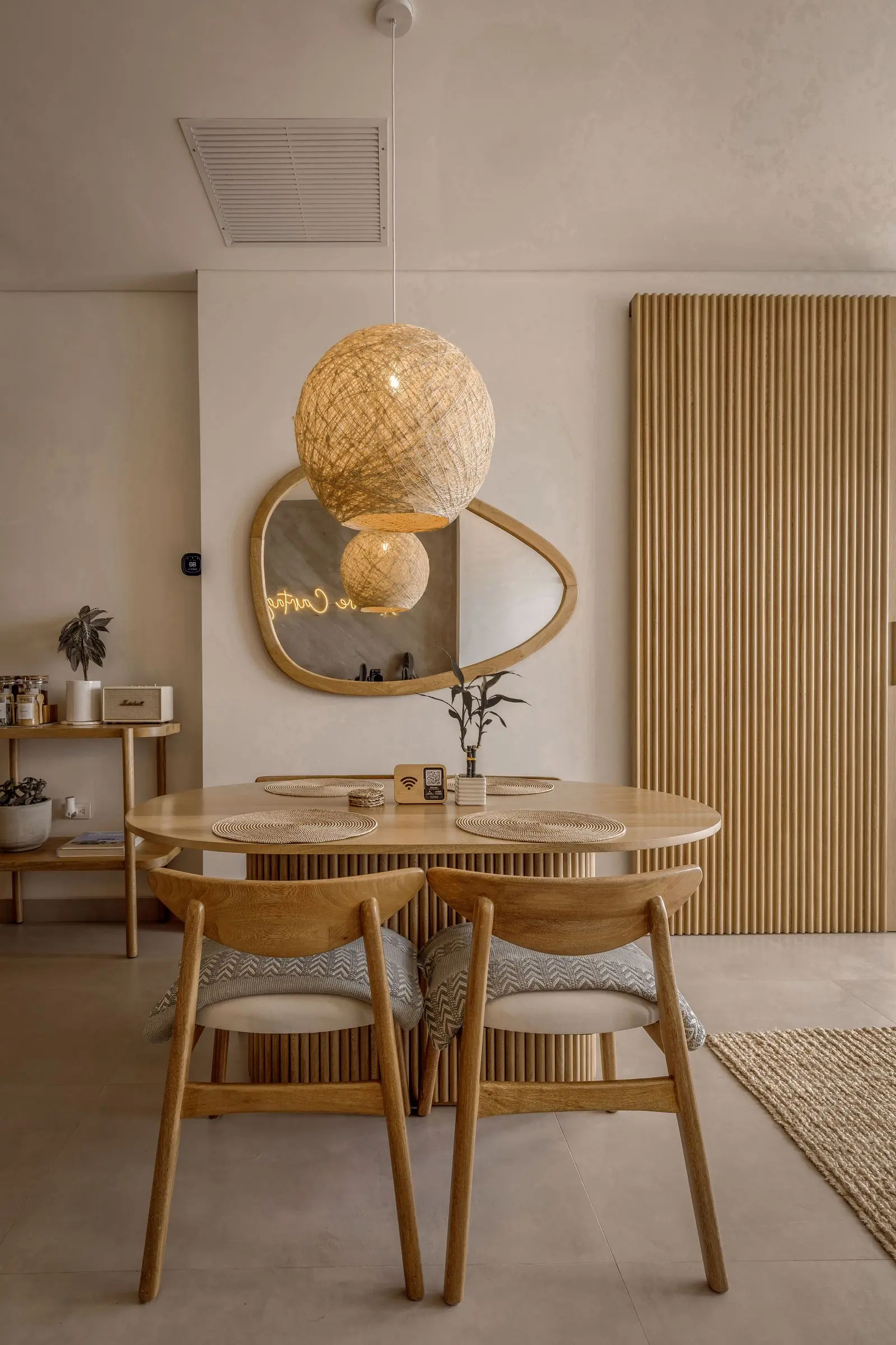 A round oak dining table set in a sunlit room