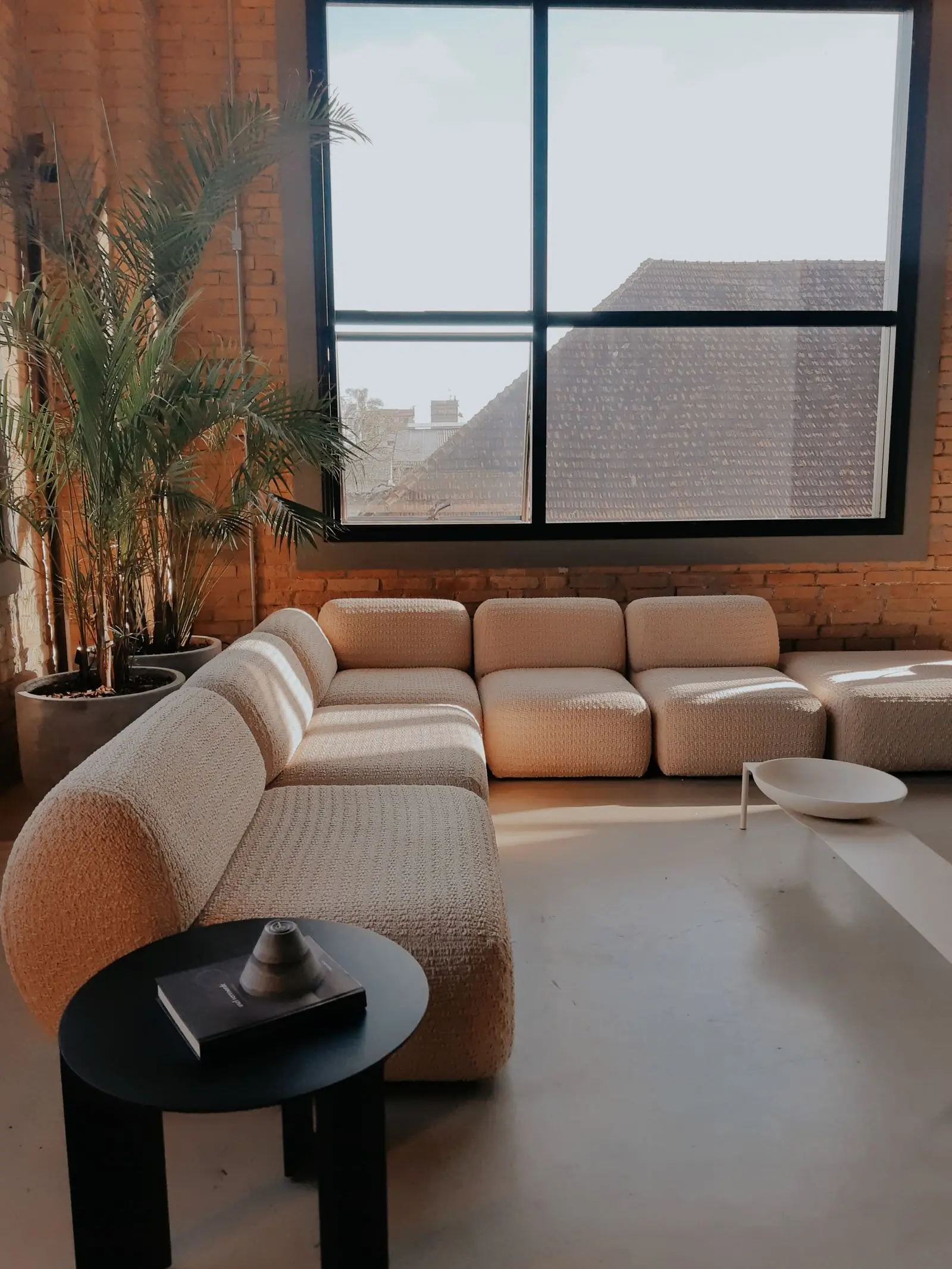 A pale linen sectional sofa in a bright minimal living room