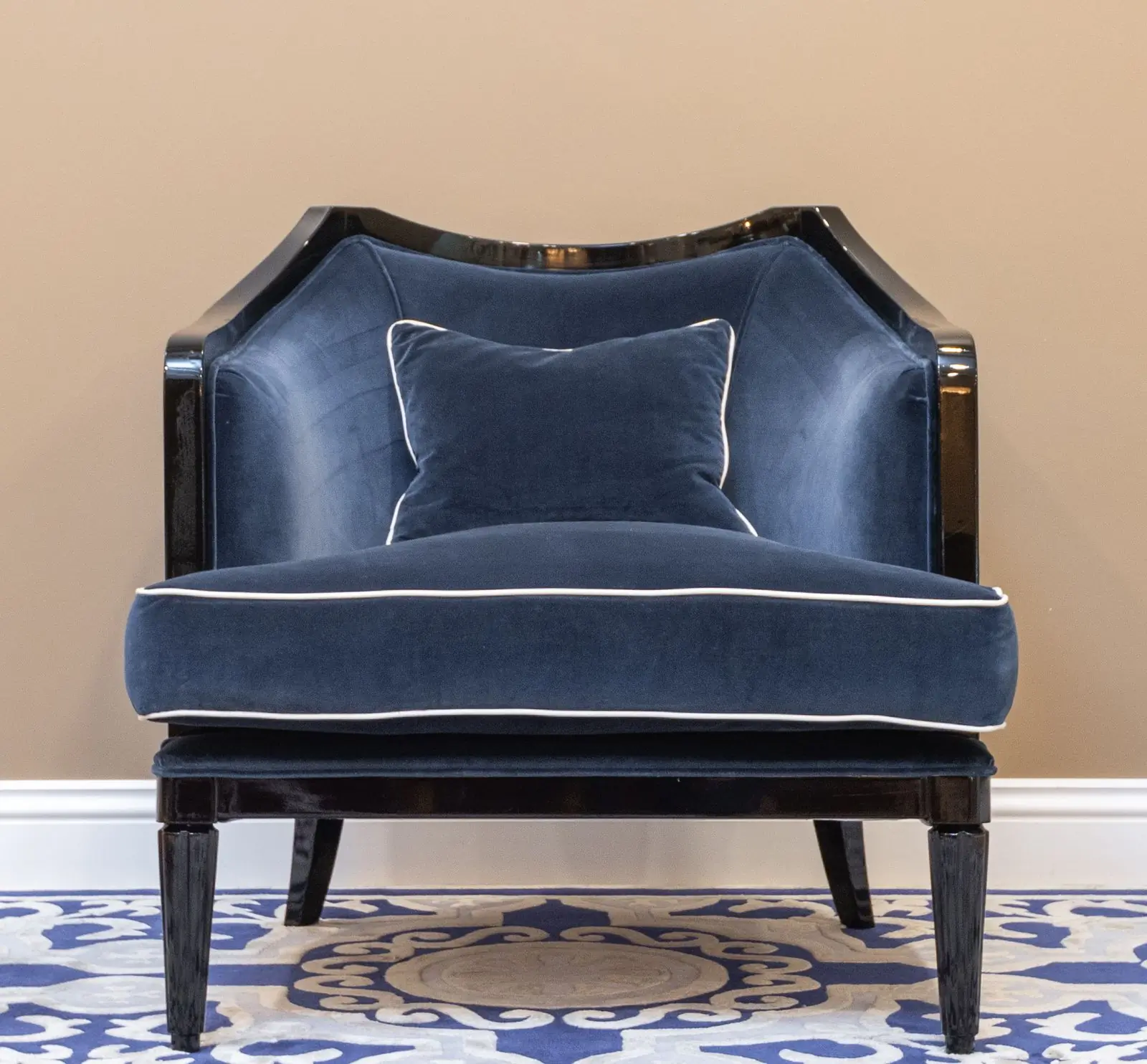 A velvet armchair in a muted tone by a window
