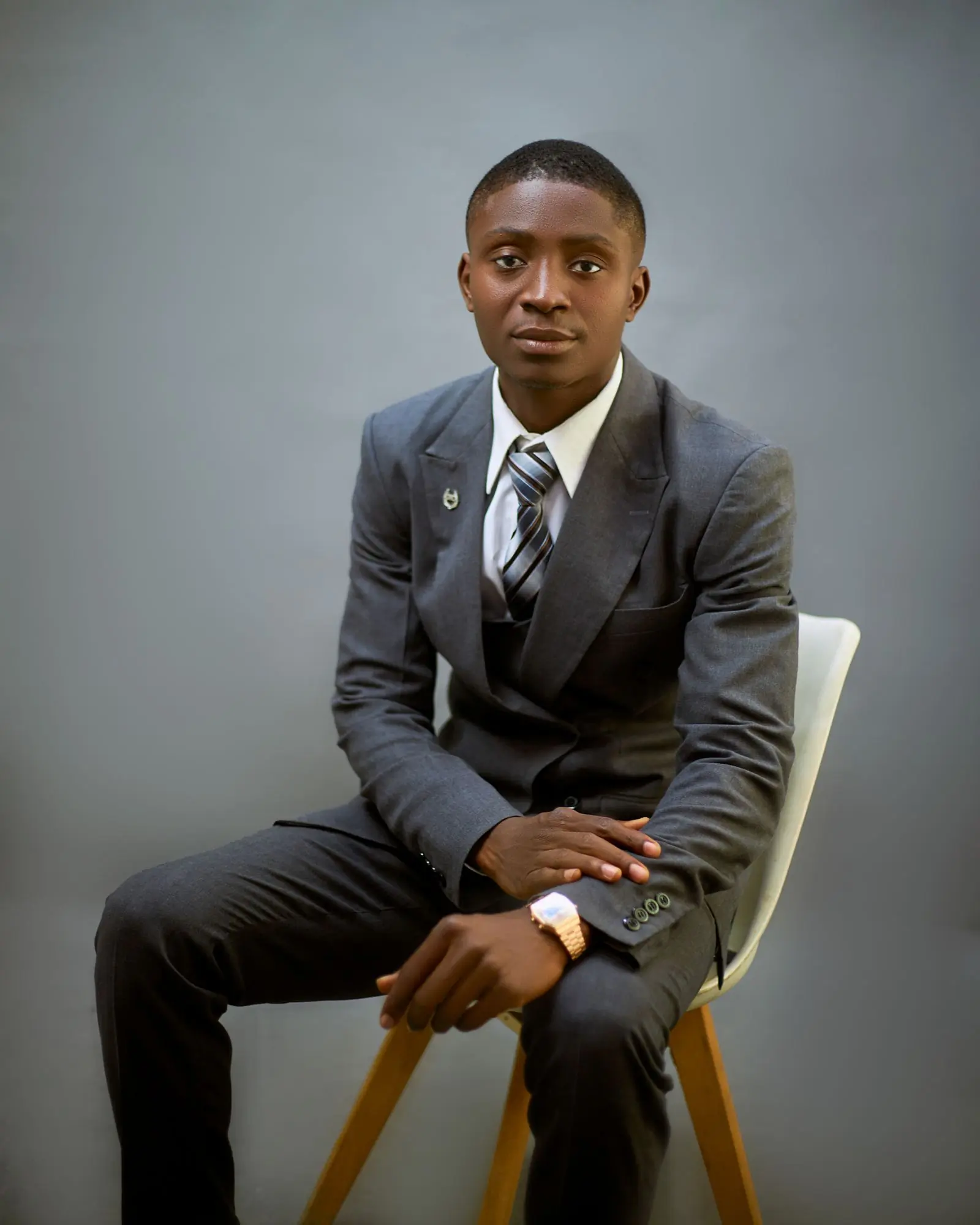 Portrait of the founder in a grey suit against a plain studio backdrop