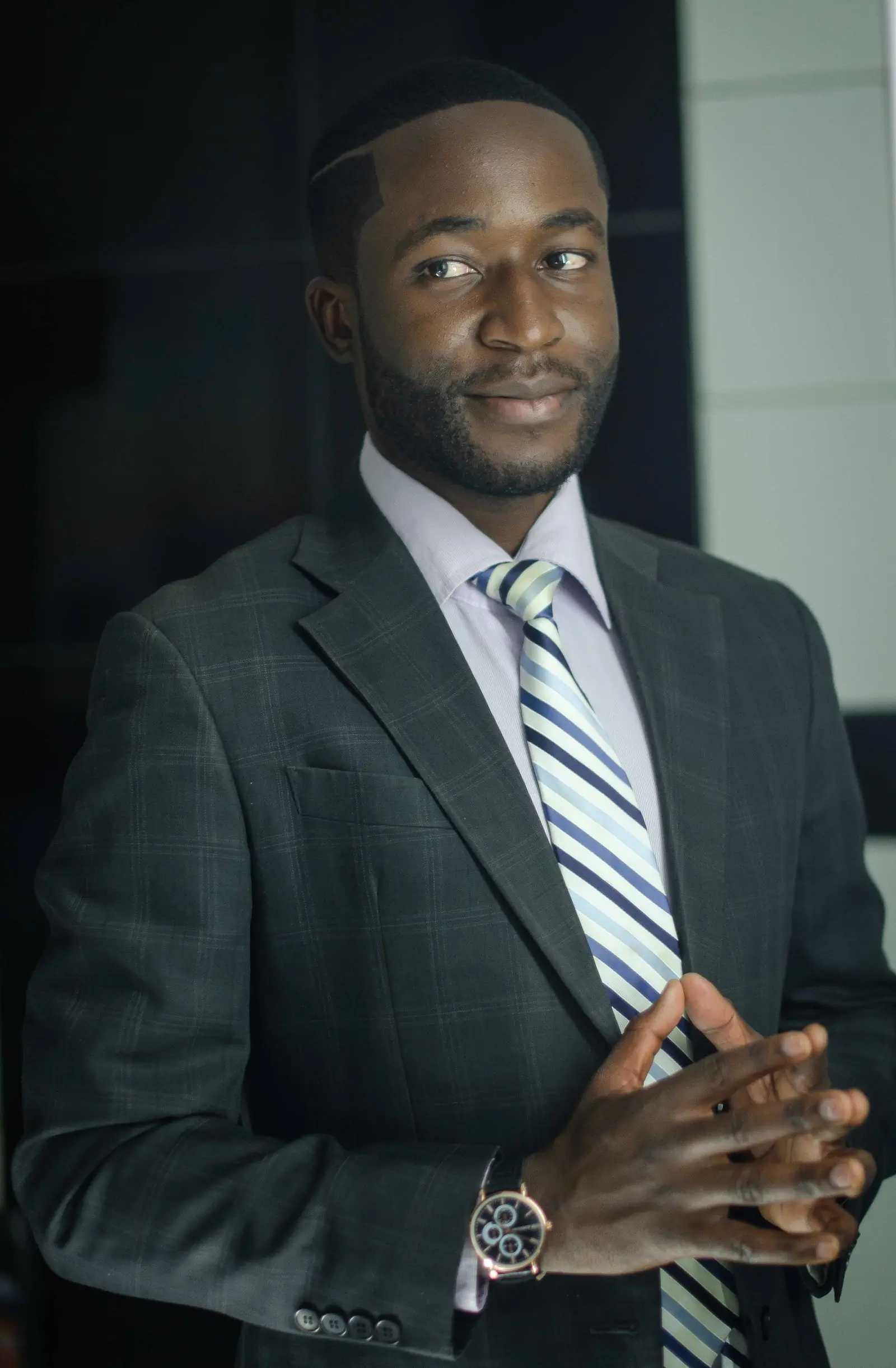 Portrait of the showroom manager, bearded, in a dark suit by a bright window