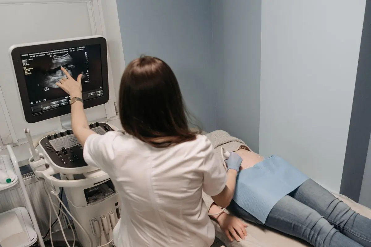 A sonographer talking a mother through her scan
