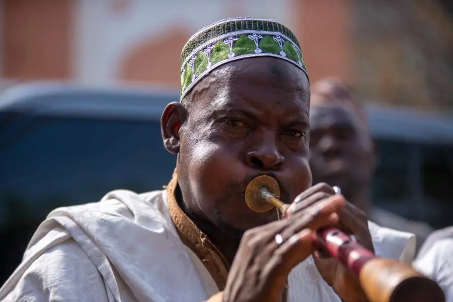 A musician playing a traditional wind instrument outdoors