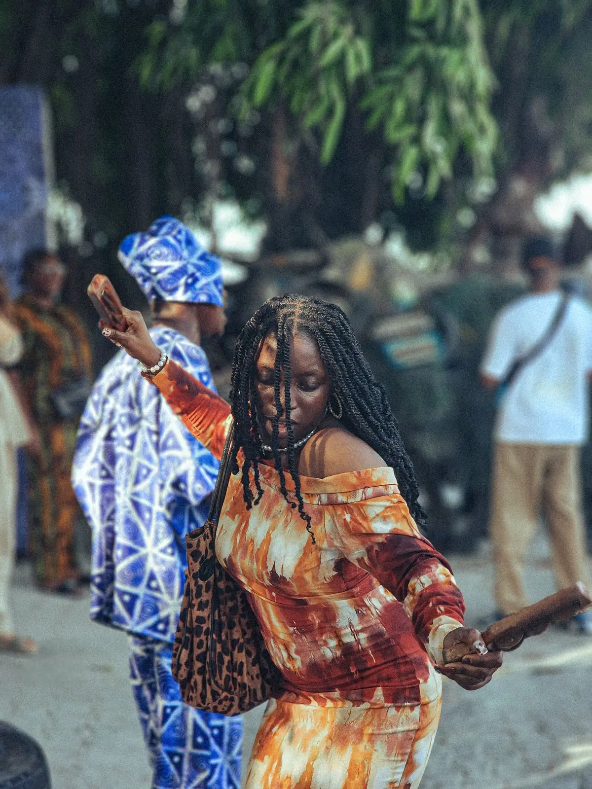 A dancer mid-step in patterned cloth at an outdoor celebration