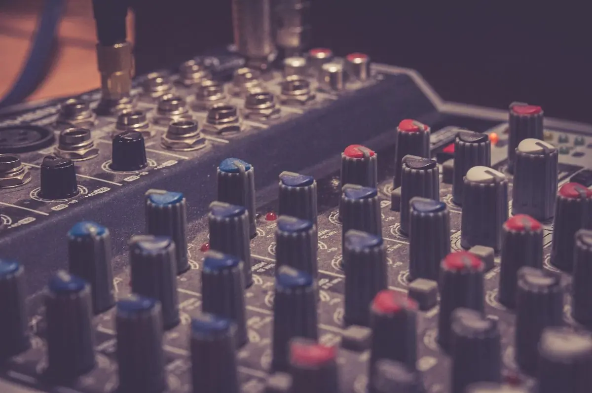 The illuminated knobs and faders of a live sound desk