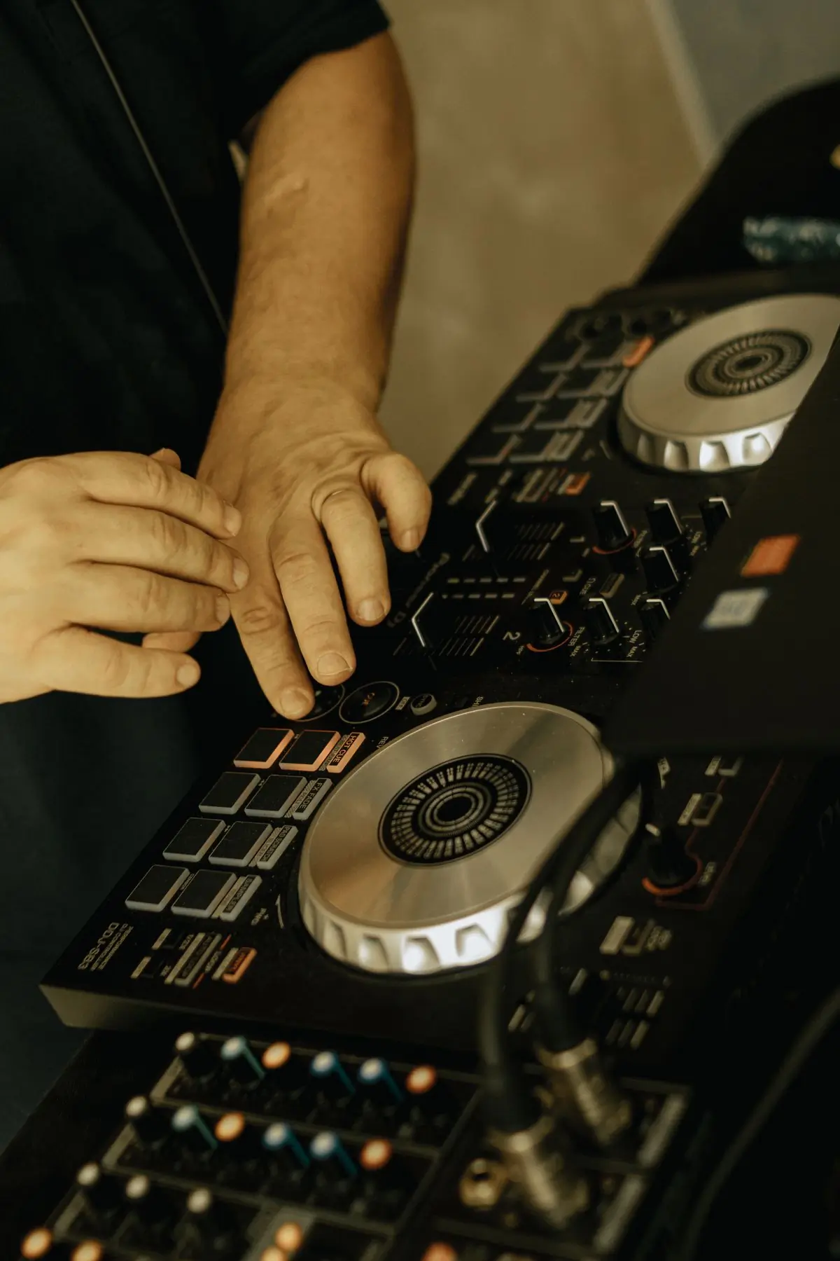 An engineer's hands across the faders of a live sound desk