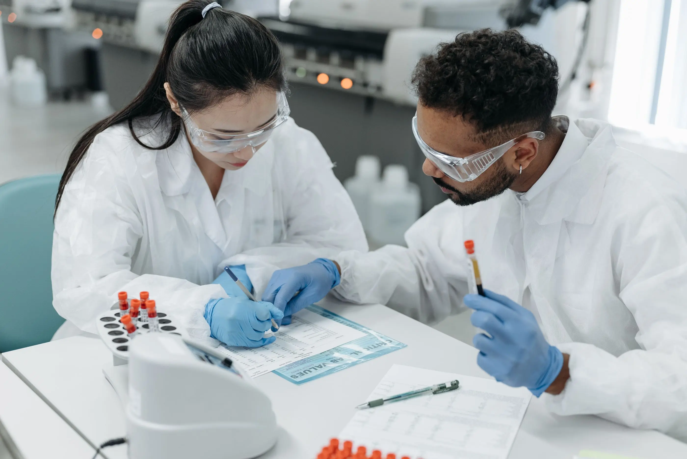 Two scientists preparing labelled sample tubes at the bench
