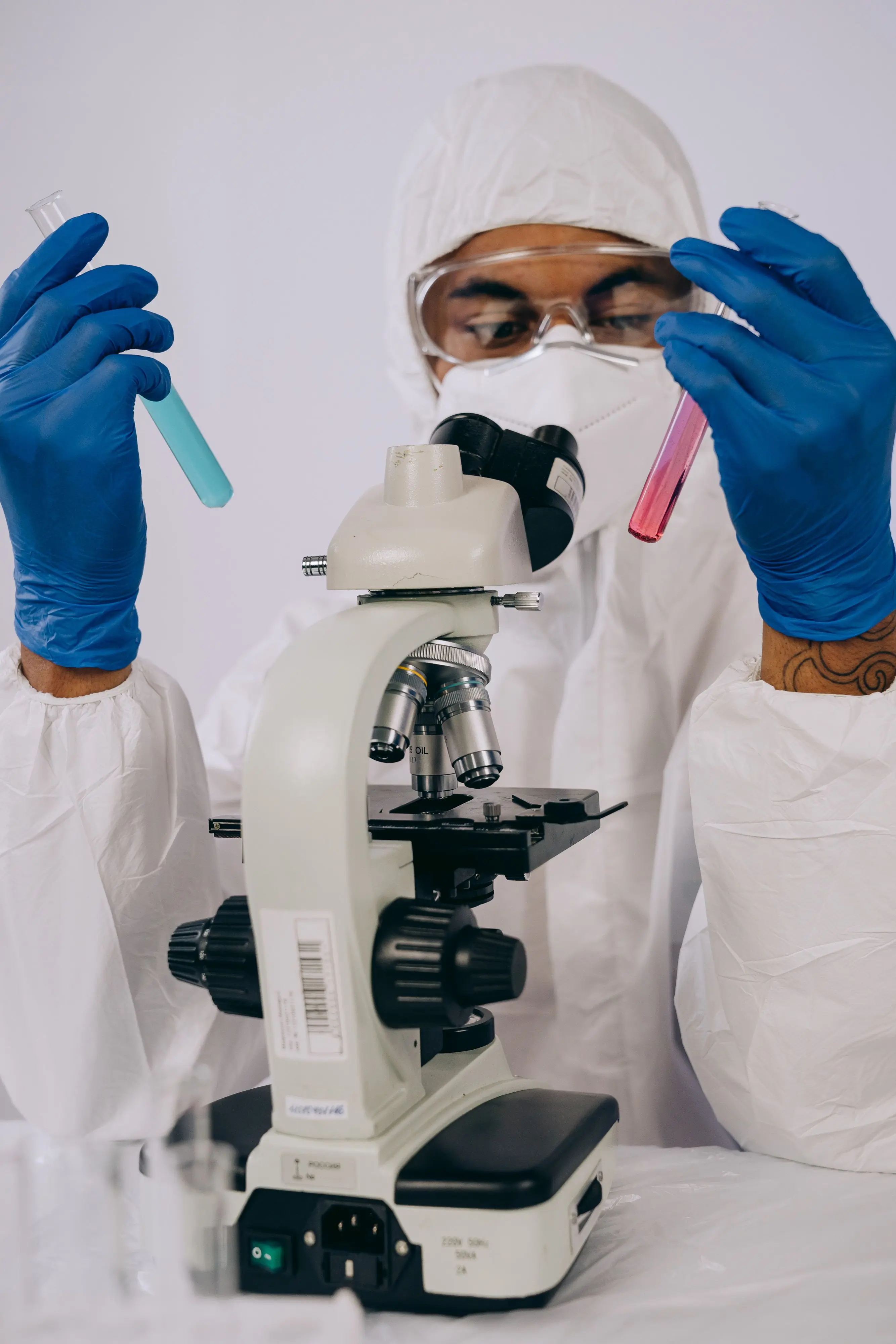 A scientist examining sample tubes at the microscope bench