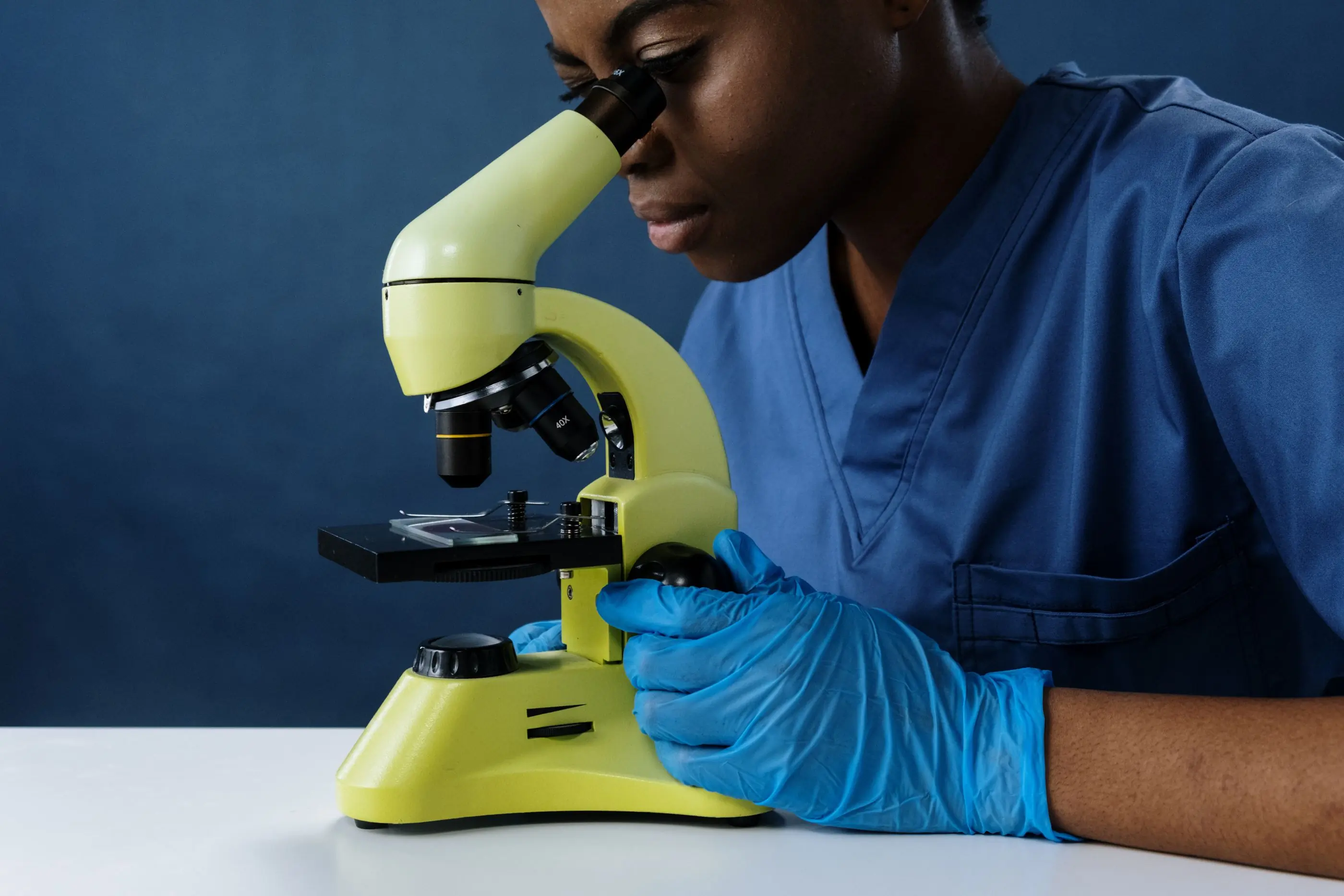 A scientist reading a slide at the microscope bench