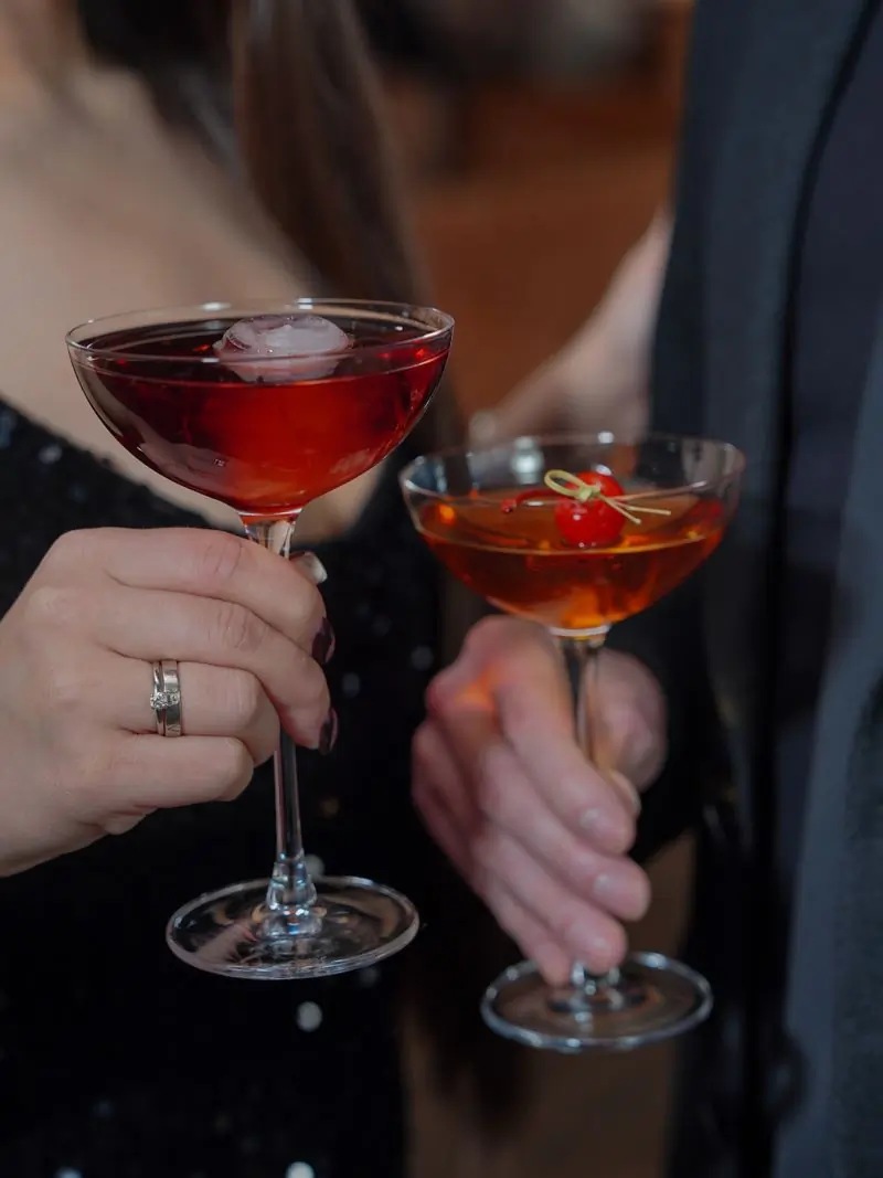 Two guests raising cocktail glasses