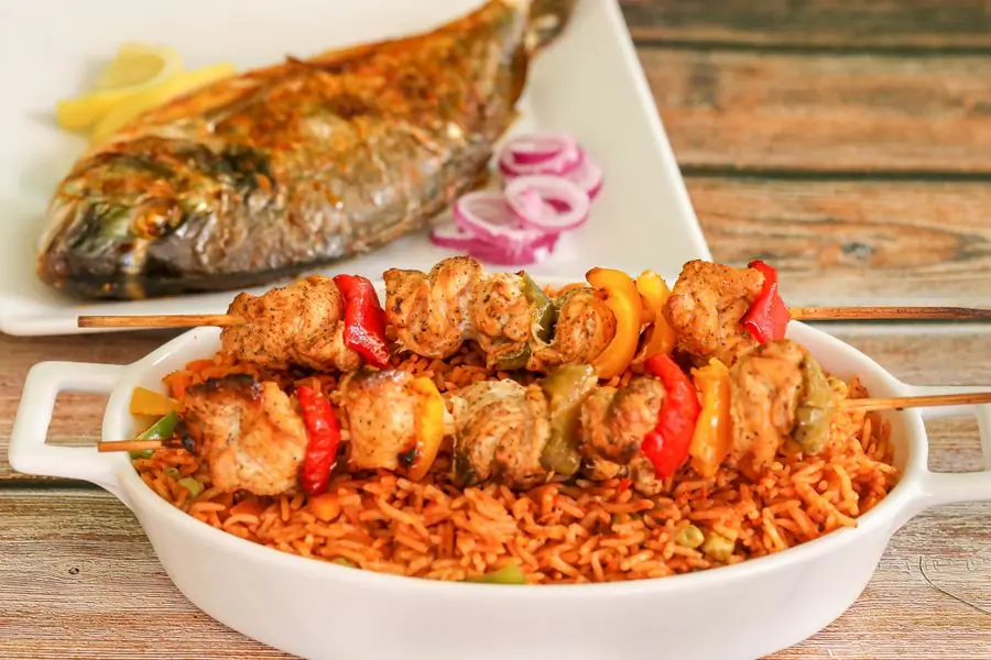Rice with grilled fish and peppers on a serving dish
