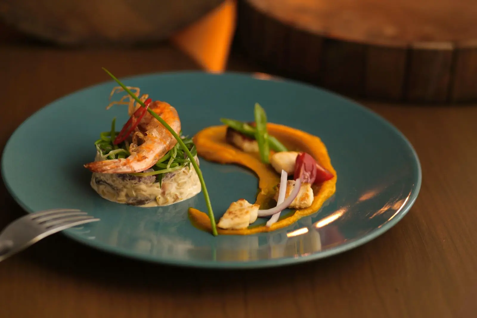 A prawn starter plated with herb oil