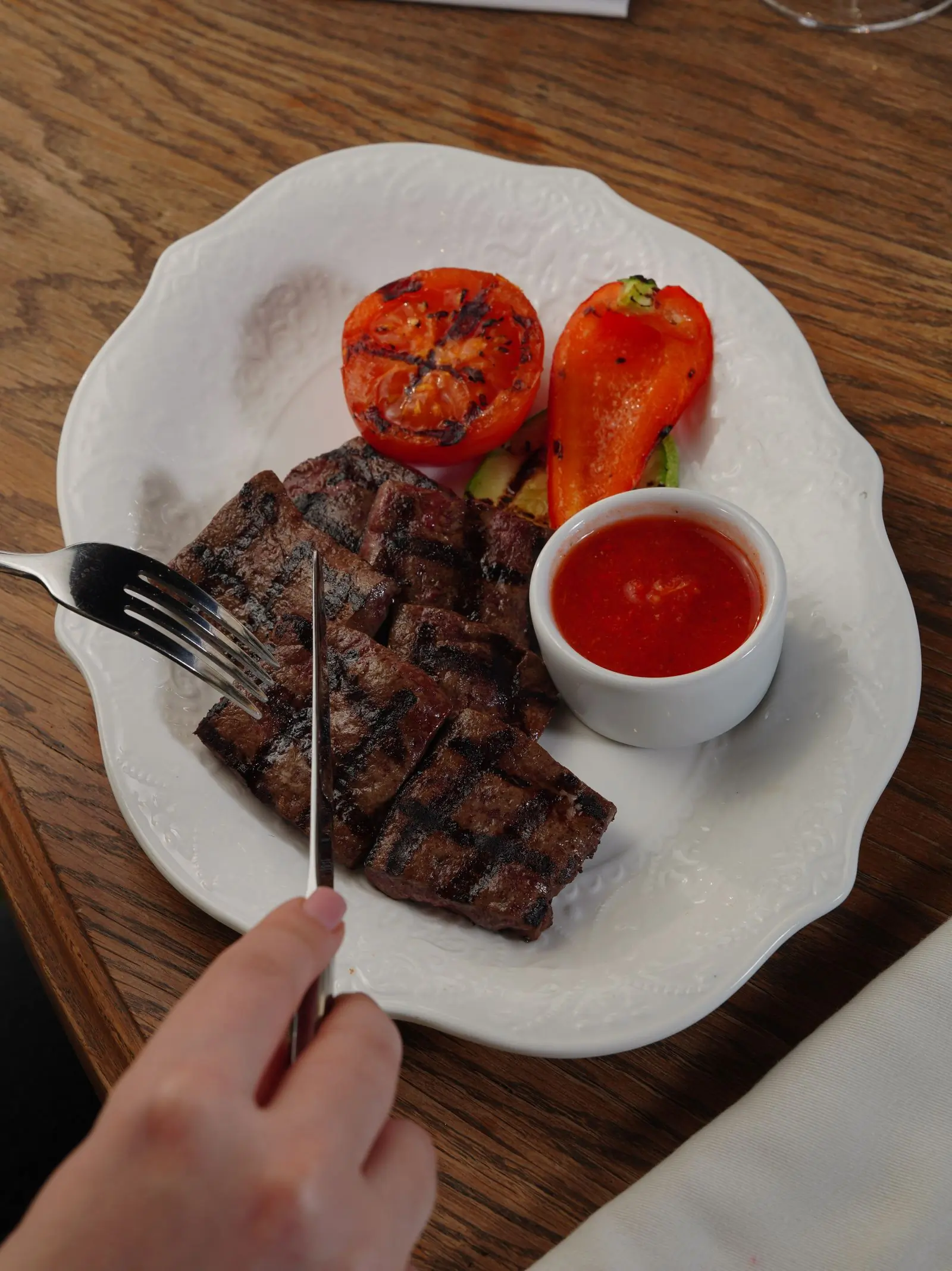 Grilled beef with roasted tomatoes on a wooden board