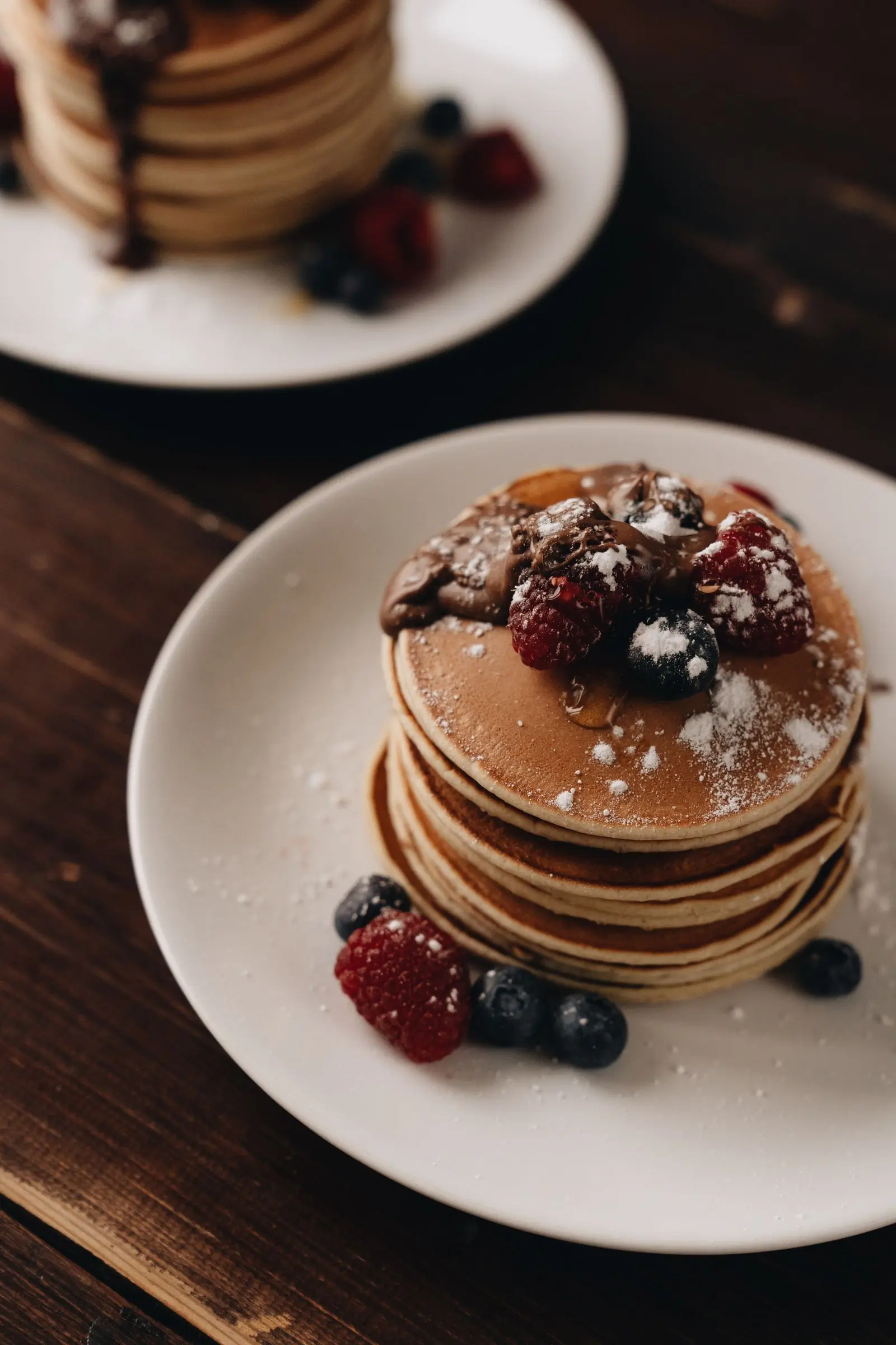 A stack of pancakes with berries and syrup