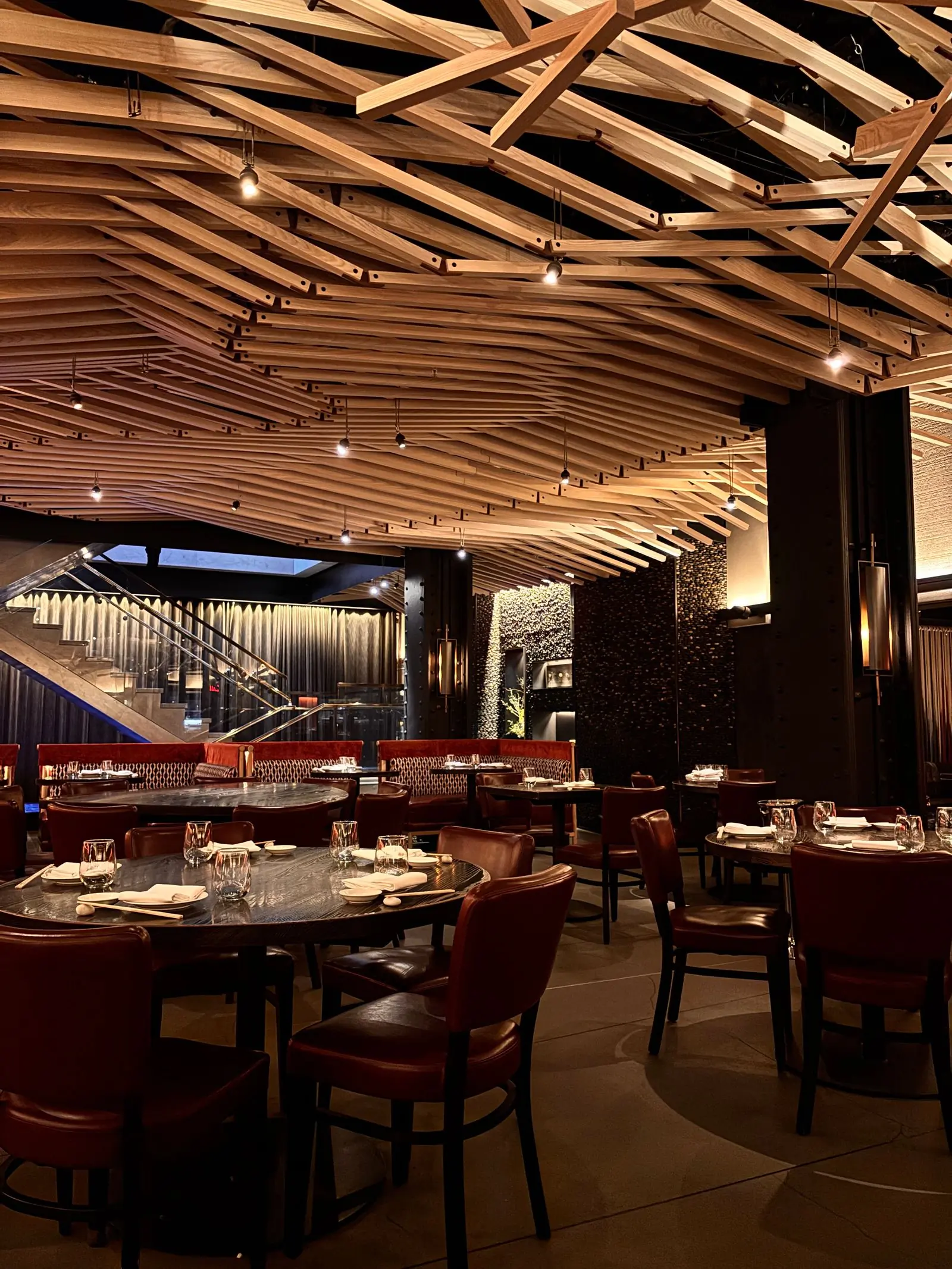 The dining room at Basil under its slatted wooden ceiling, laid for dinner