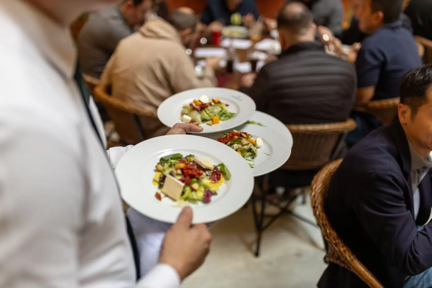 A server carrying plates through the dining room at Basil