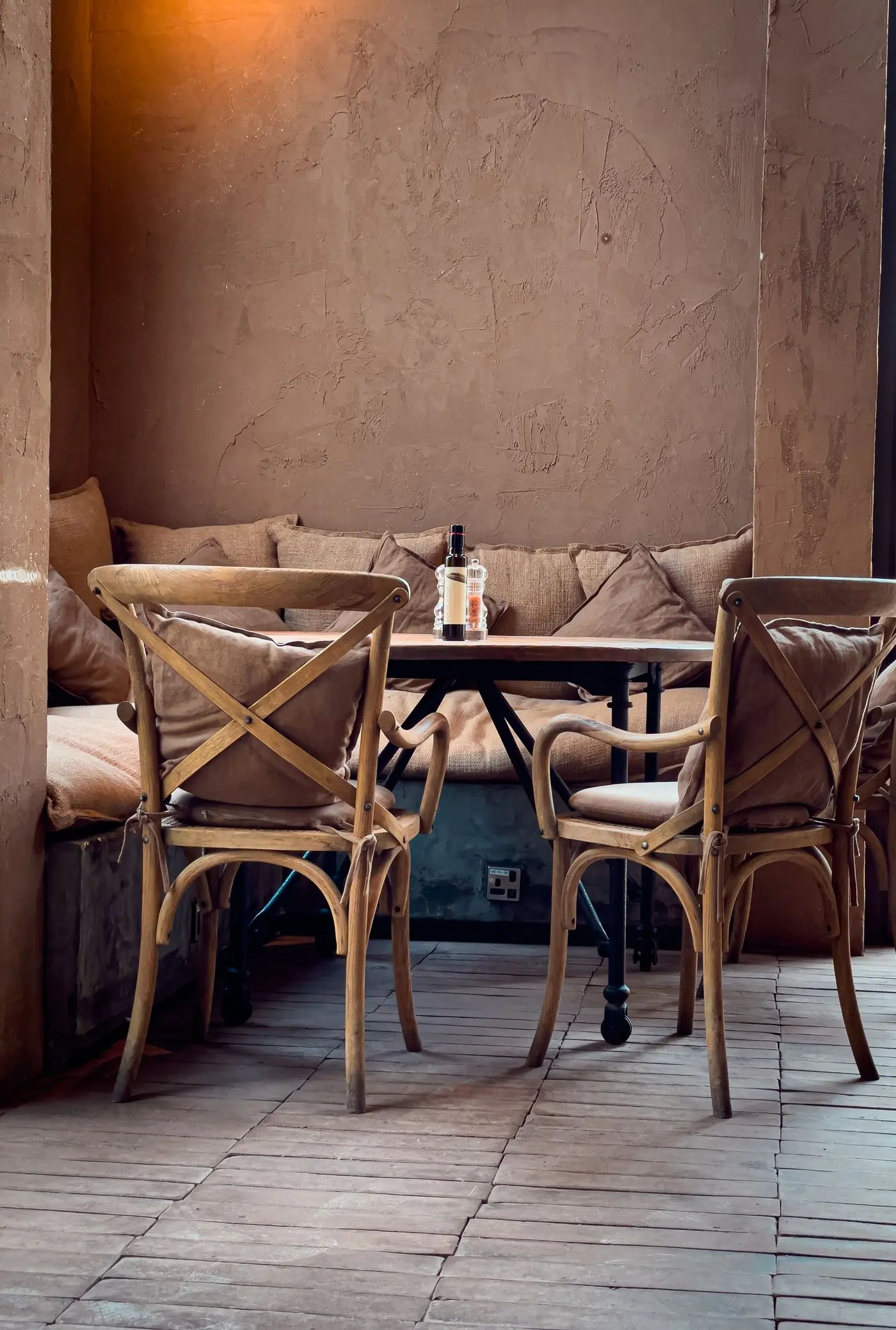 A corner of the room at Basil, chairs and a banquette laid for a small party