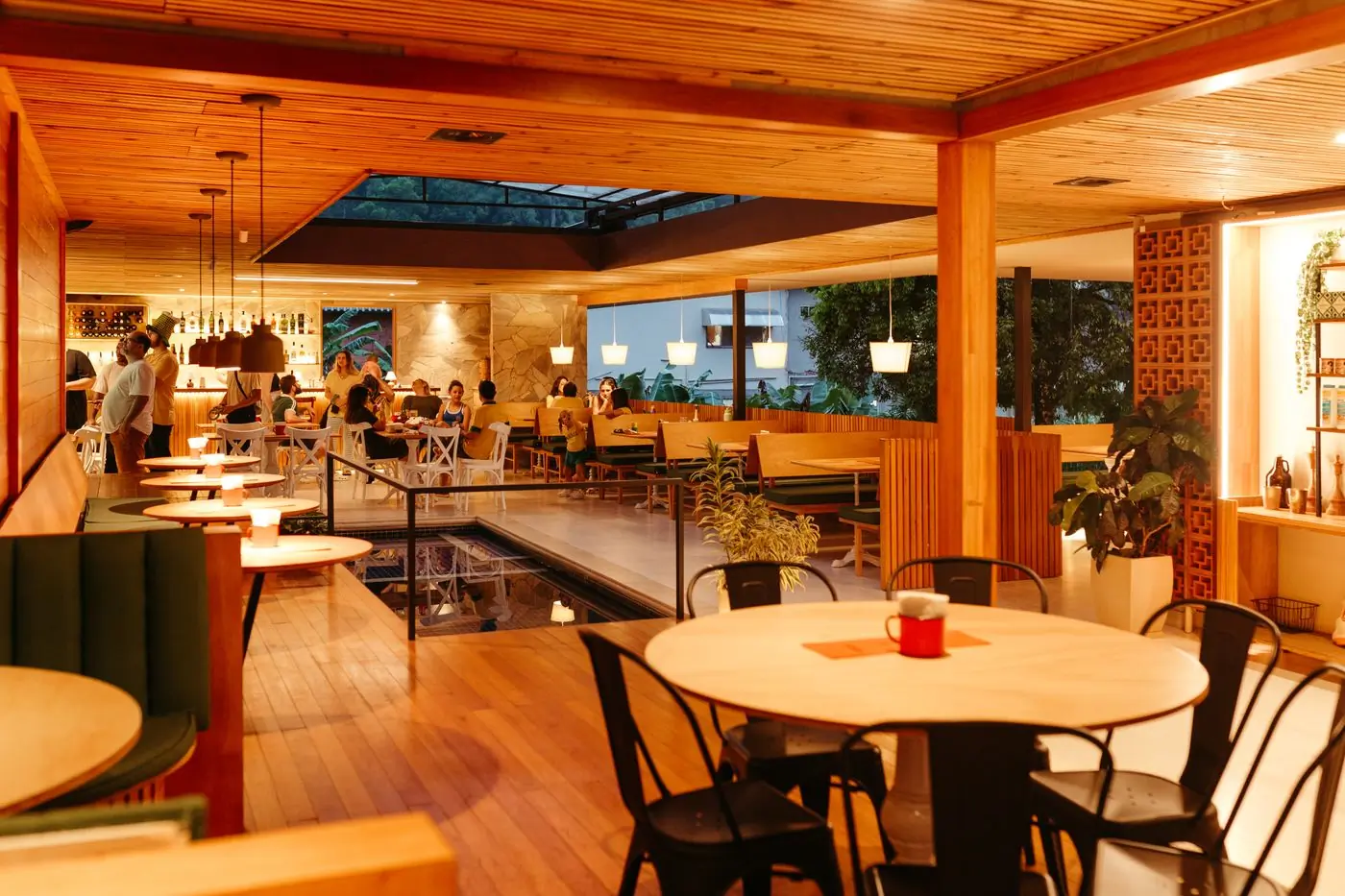 The dining room at Basil, wooden tables under warm lamps