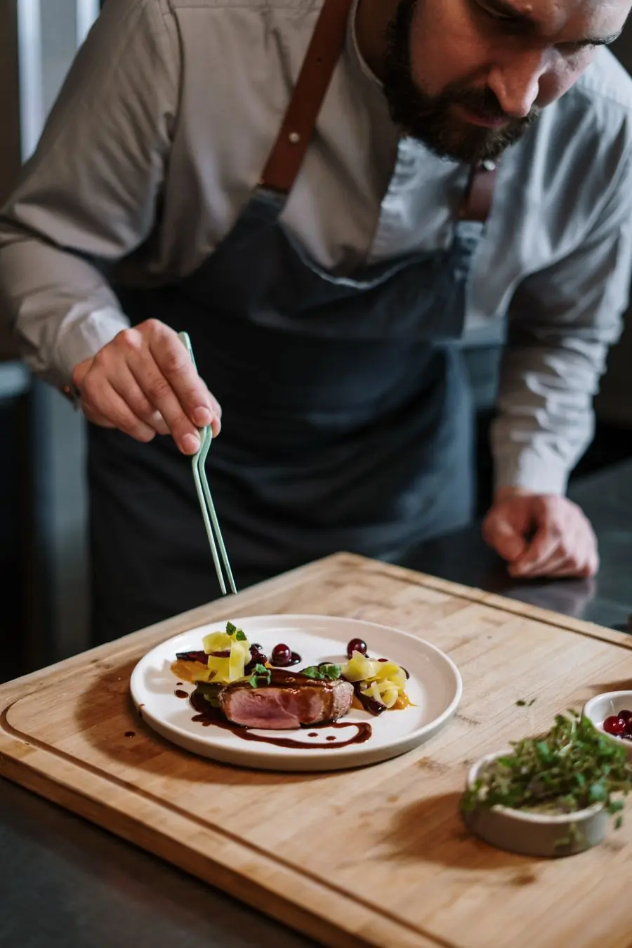 A chef finishing a plate at the pass at Basil