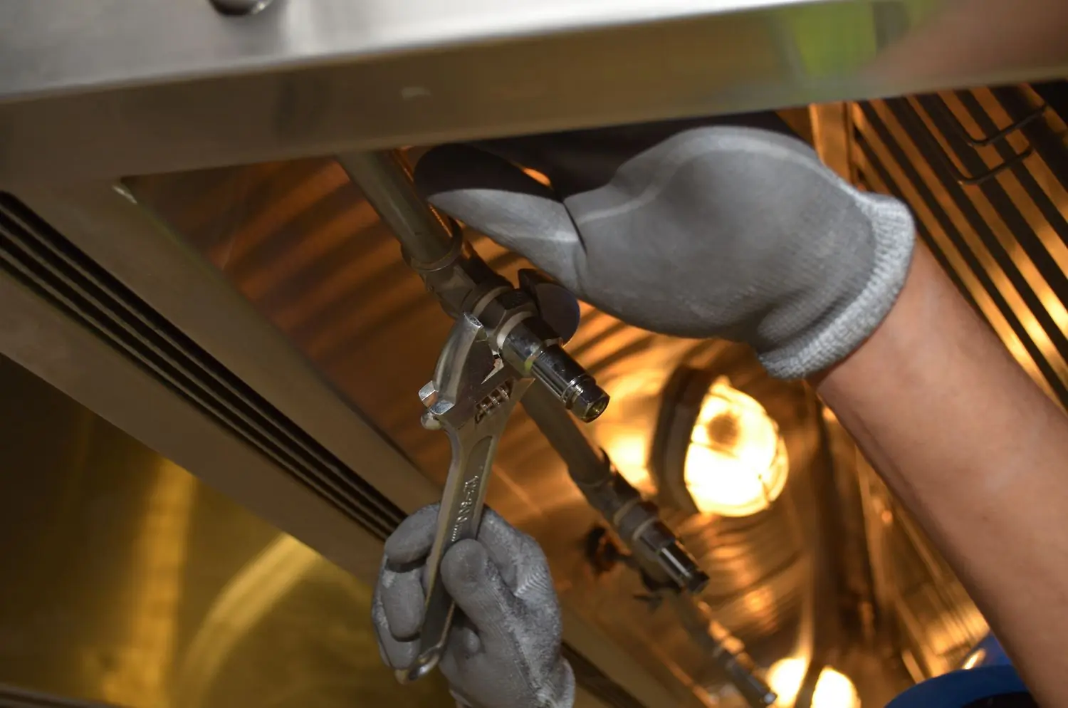 A Beacon plumber making up pipework under a fitted unit