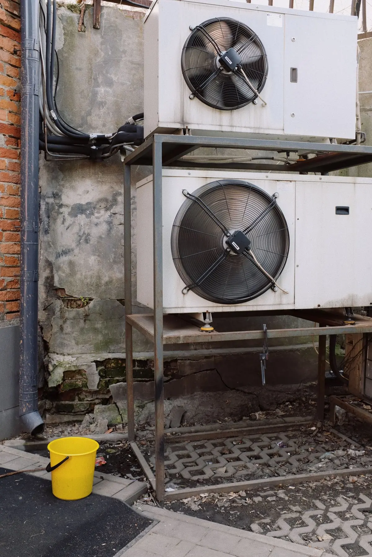 A condenser unit on its frame outside an office block
