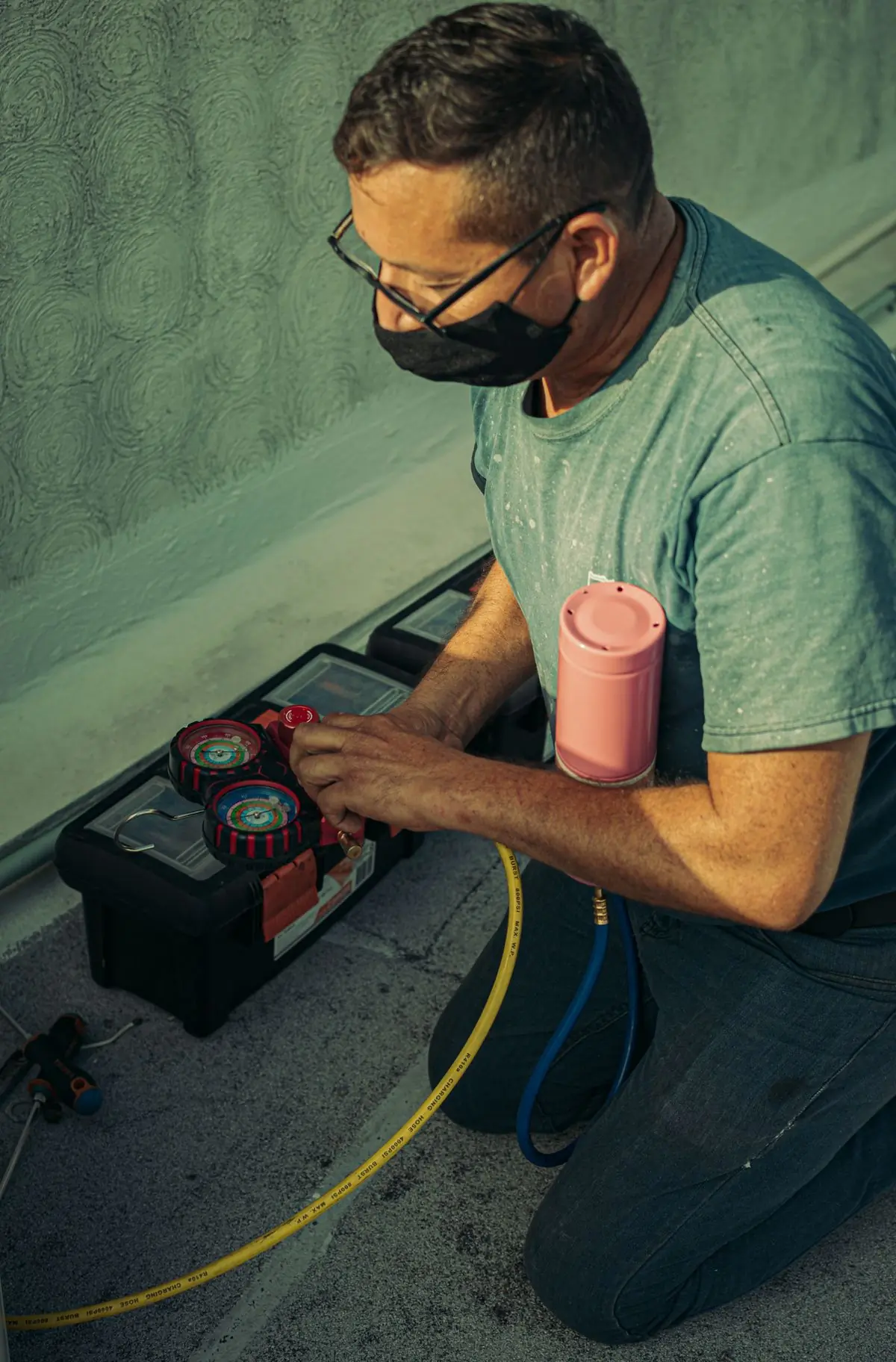 A refrigeration engineer charging a system through a manifold gauge set