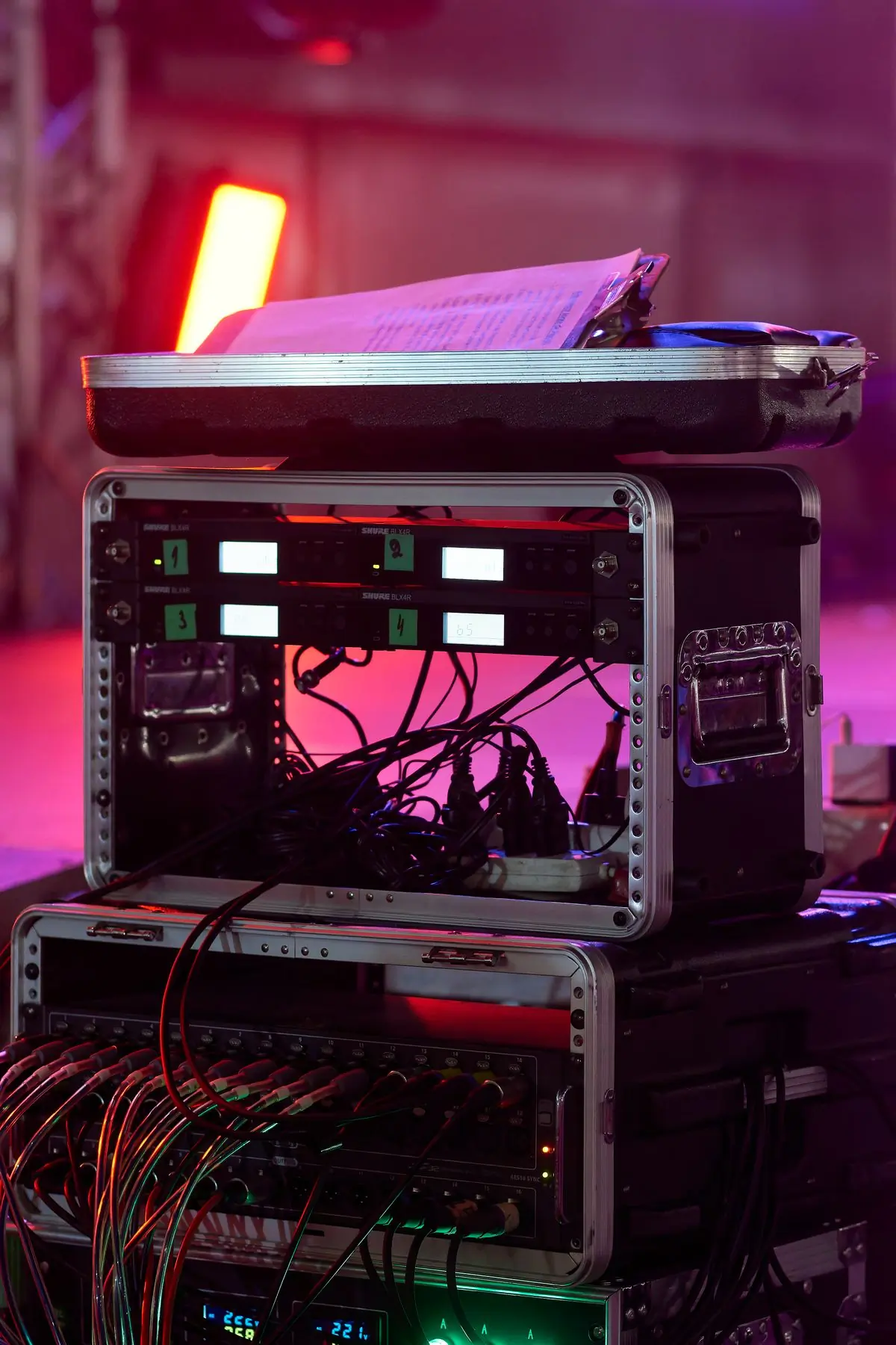 A flight case of audio equipment lit by stage colours