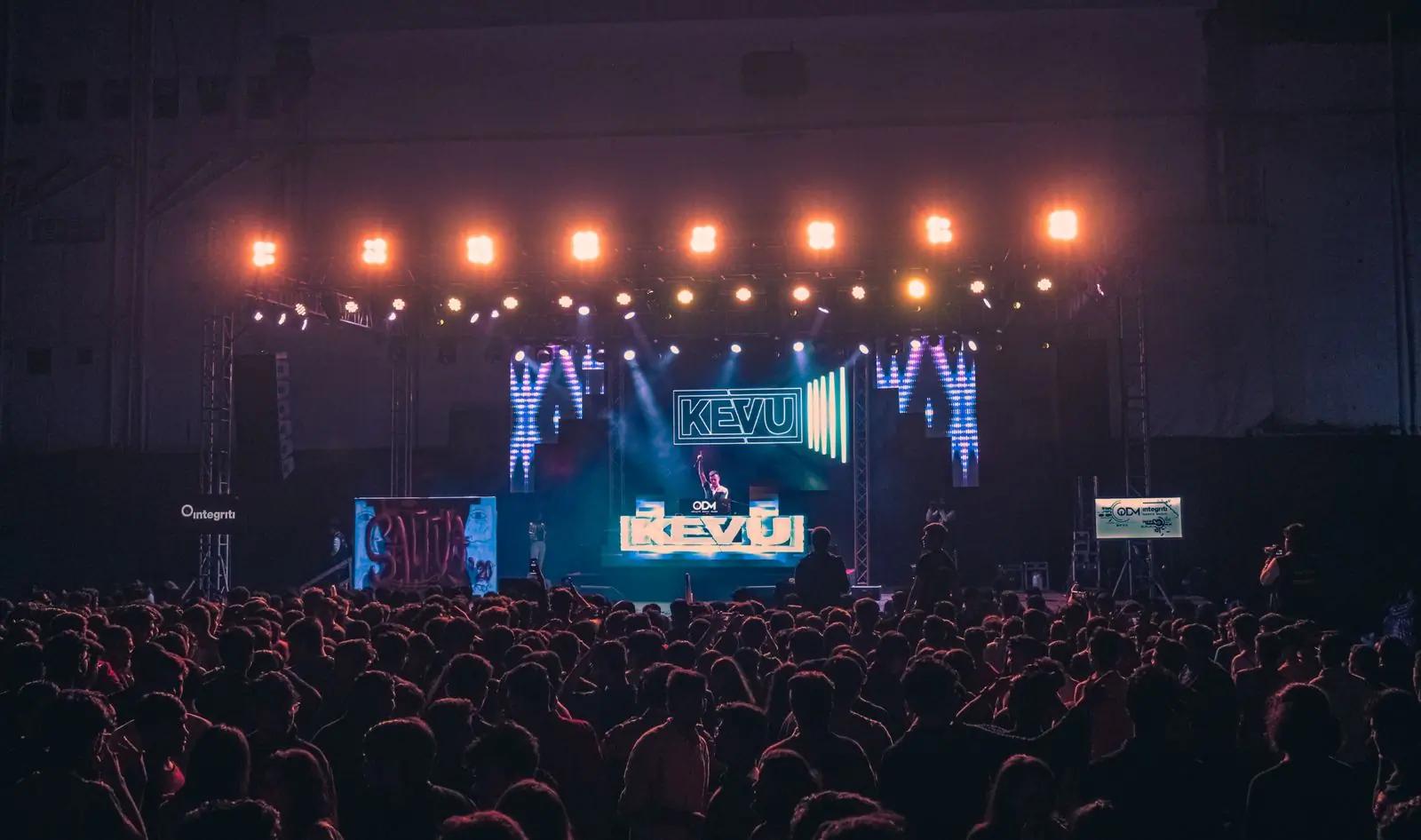 A festival main stage lit in orange in front of a full crowd