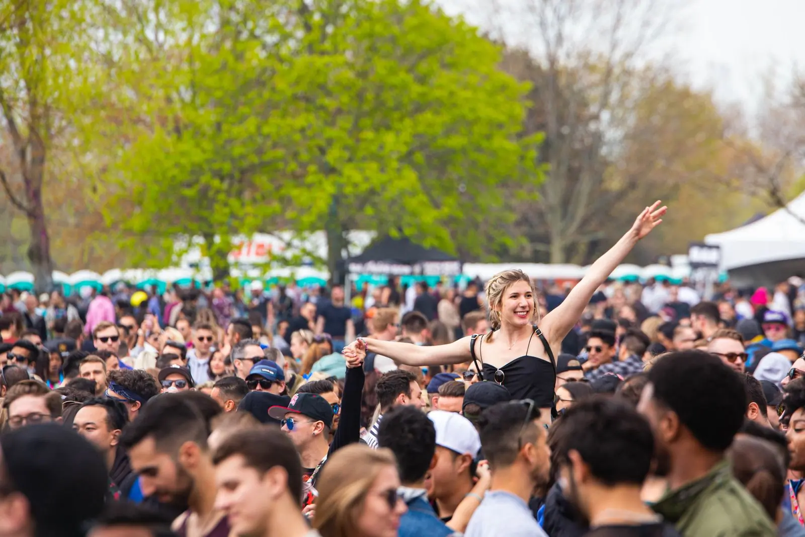 An outdoor music festival crowd in bright afternoon sun
