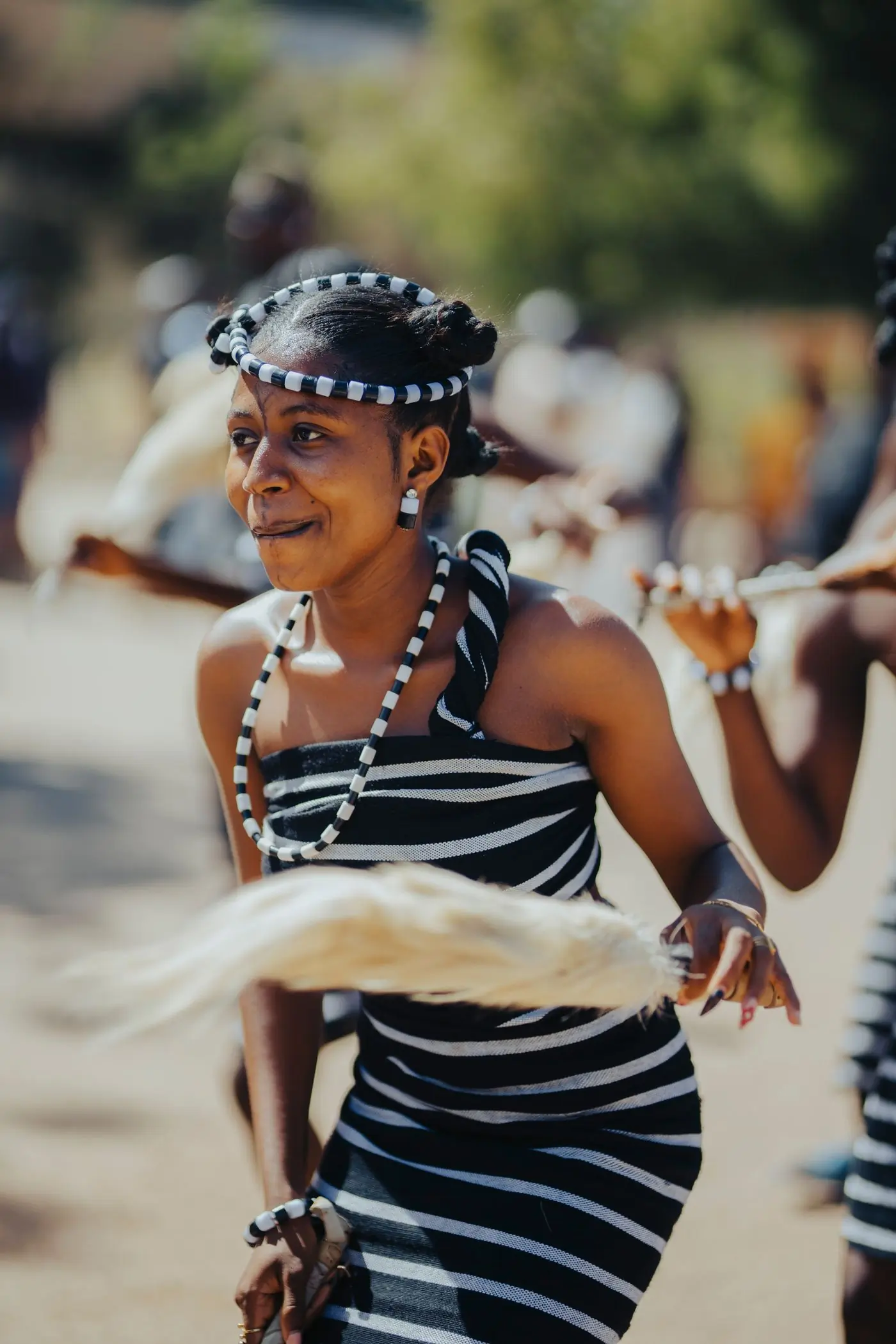 A dancer in bright traditional dress mid-movement at an outdoor festival