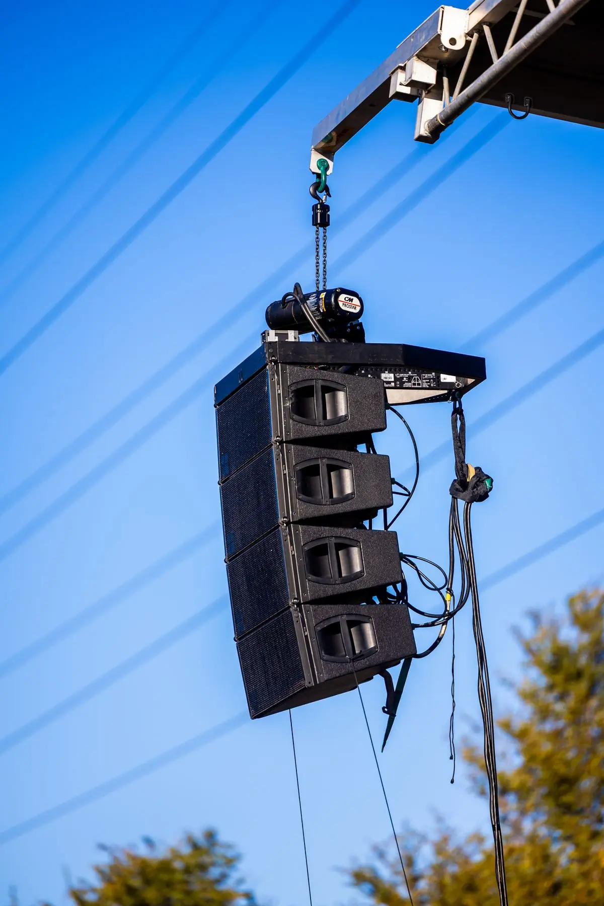 Line-array speakers hanging above an outdoor stage