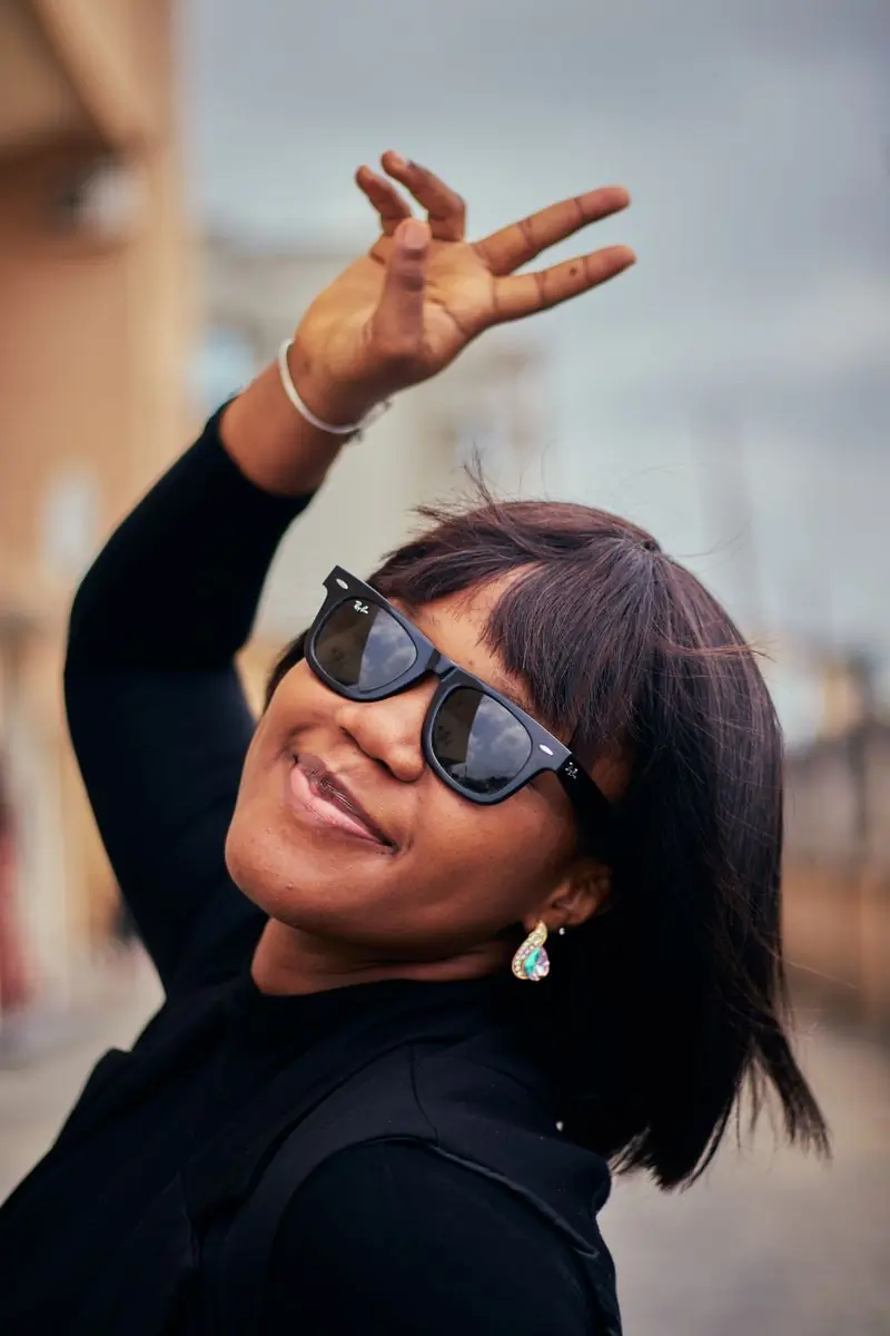 A festival-goer in sunglasses smiling in bright sunshine