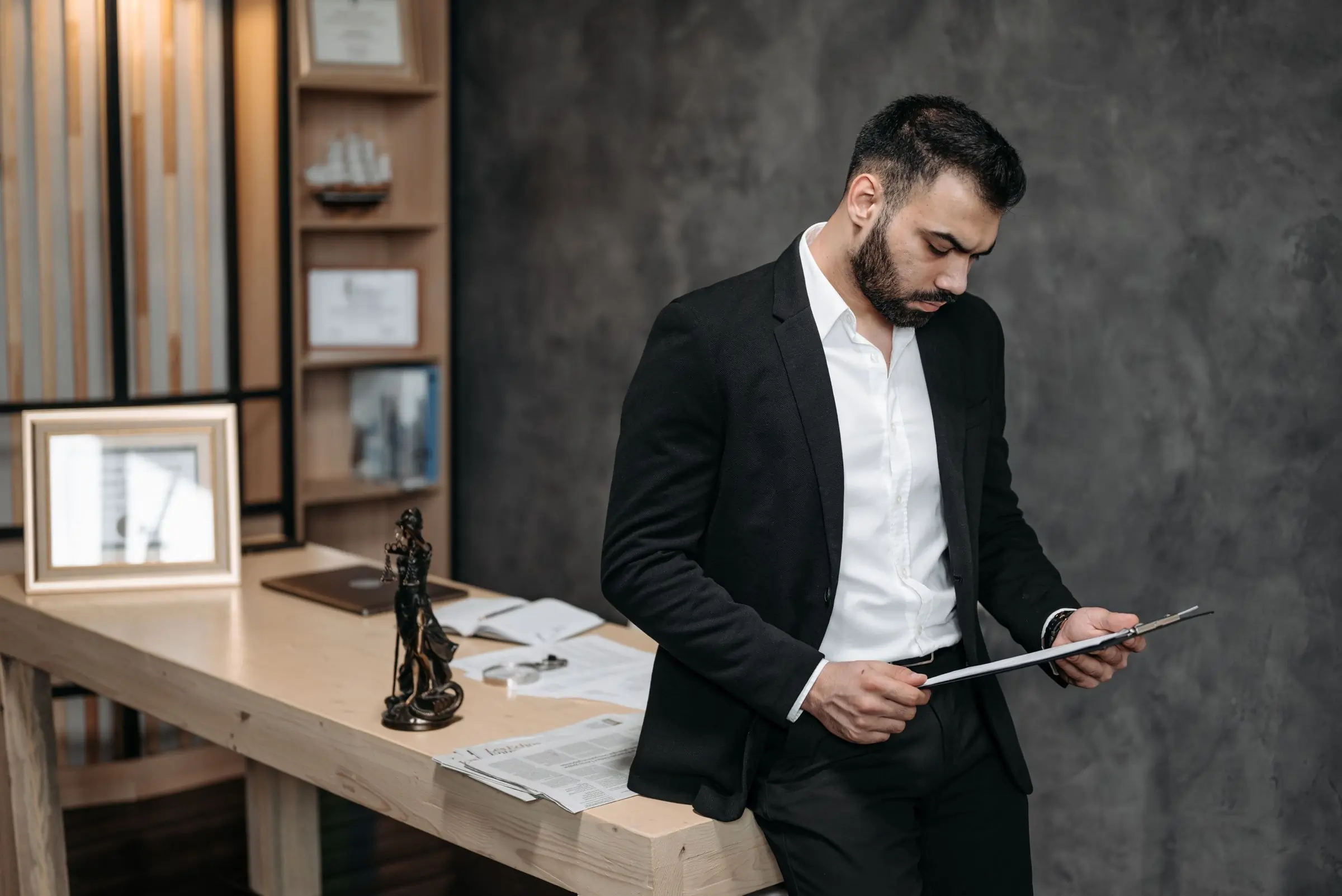 An attorney reading a document at his desk in the firm's office