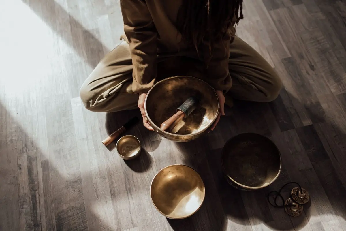 A set of Tibetan singing bowls and a mallet on a wooden floor