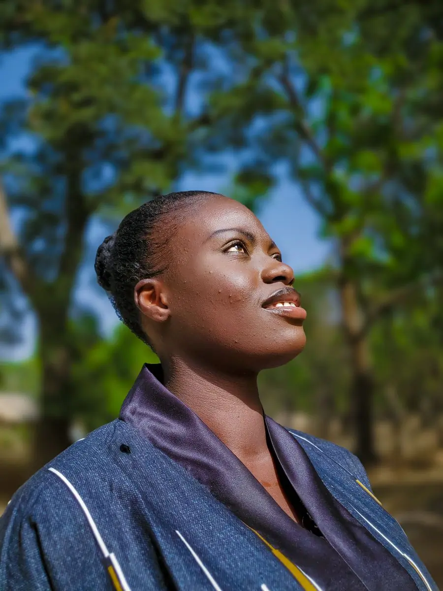 A woman looking upward in profile against a soft green background