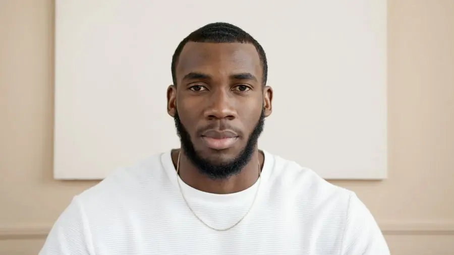 A man in a white shirt photographed against a pale background